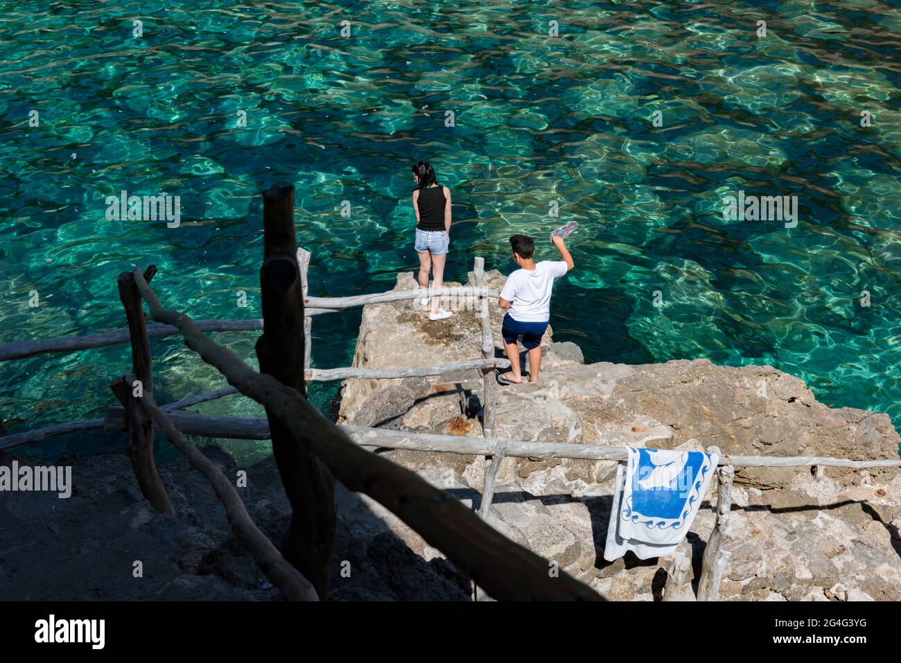 Un couple regarde les eaux cristallines au large de la côte à Deia à Majorque, Espagne Banque D'Images