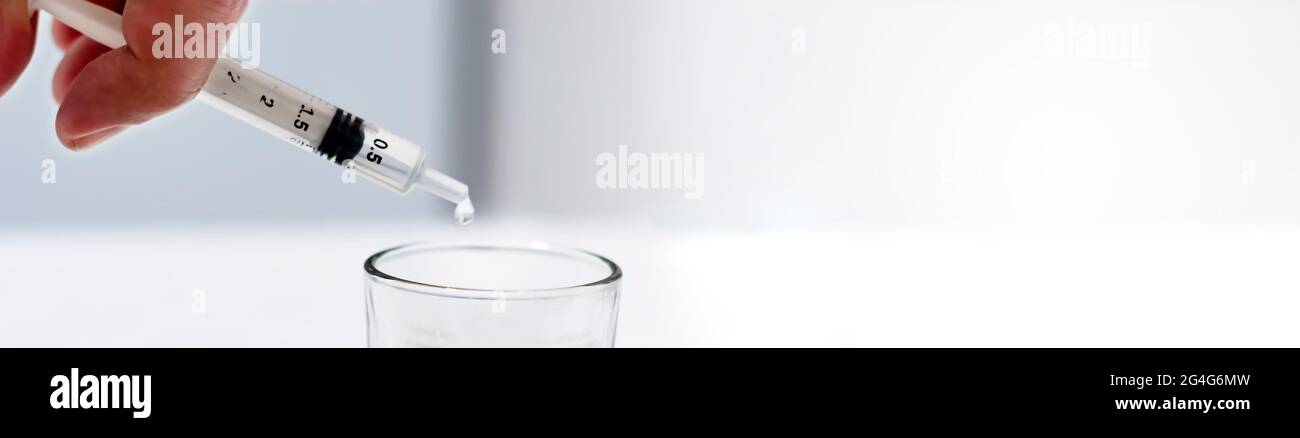 un chercheur vide le liquide d'un flacon dans un contenant en verre pour trouver un vaccin contre le virus dans un laboratoire d'analyse et de recherche scientifique. Science a Banque D'Images