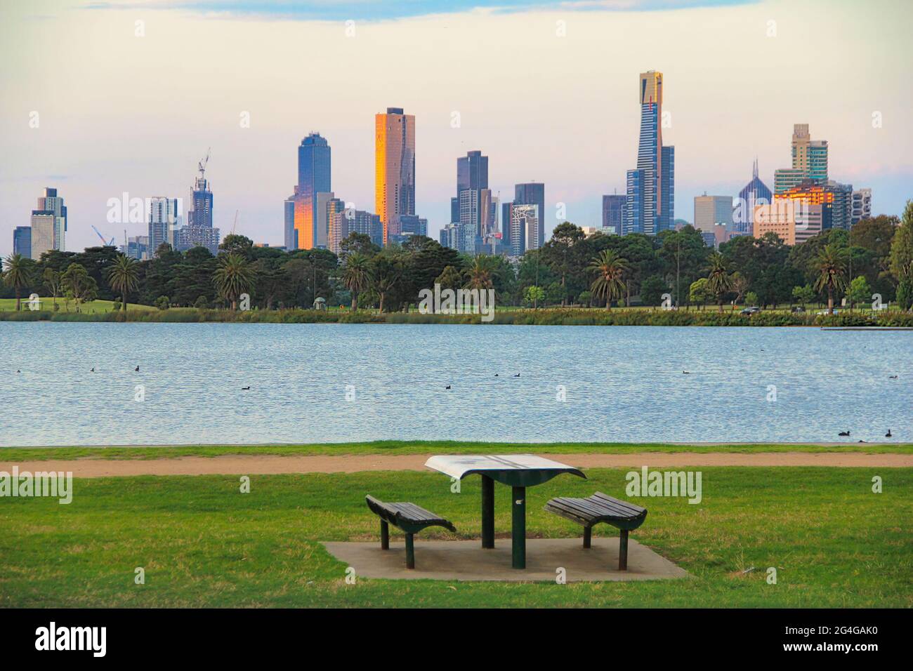 Vue sur une table de pique-nique dans un parc public avec le fond des bâtiments de la haute hauteur du quartier des affaires de Melbourne, Australie. Banque D'Images