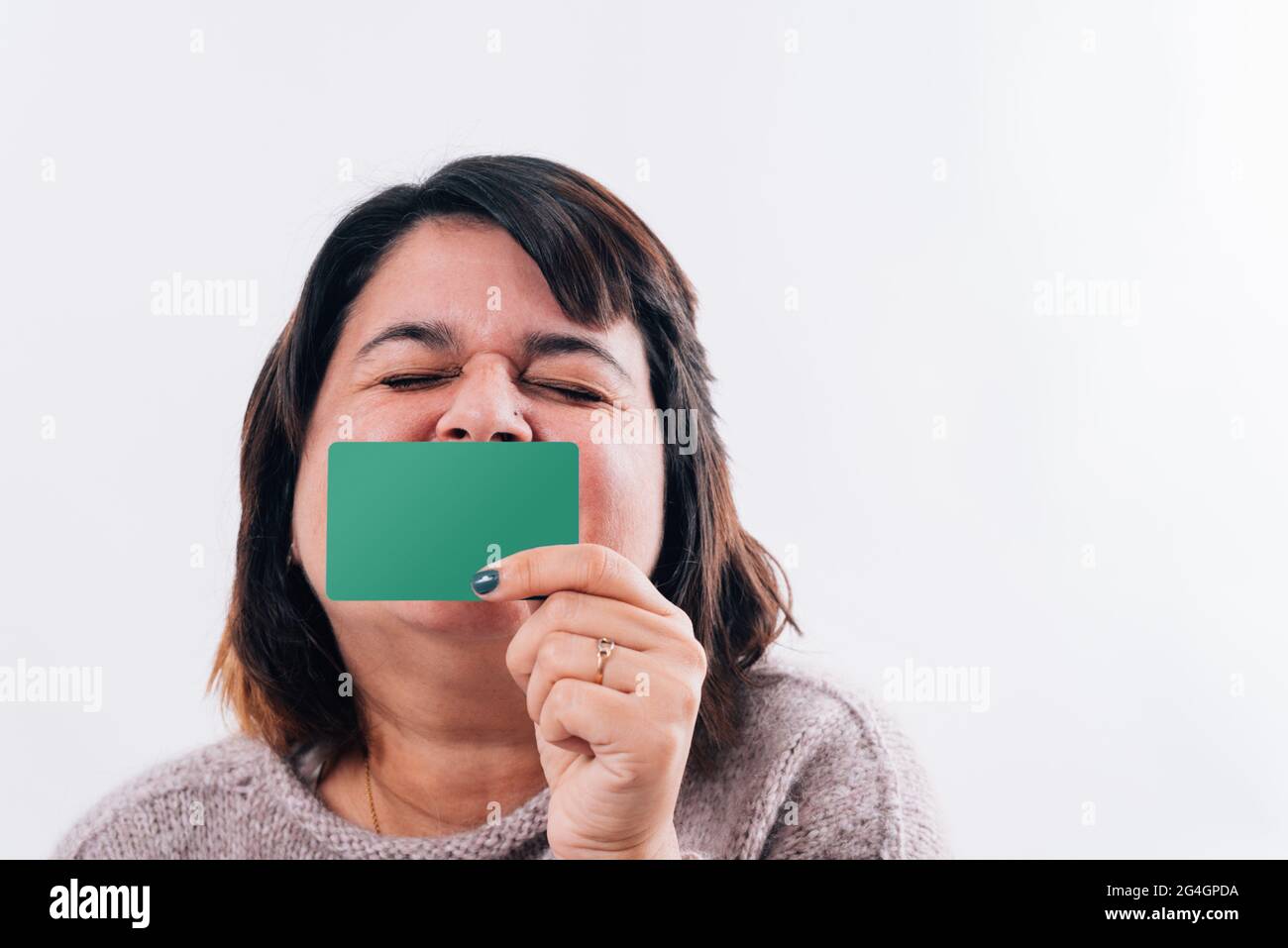 Une femme excitée embrasse une carte de crédit. Embrasser une carte d'achat. Copier l'espace Banque D'Images