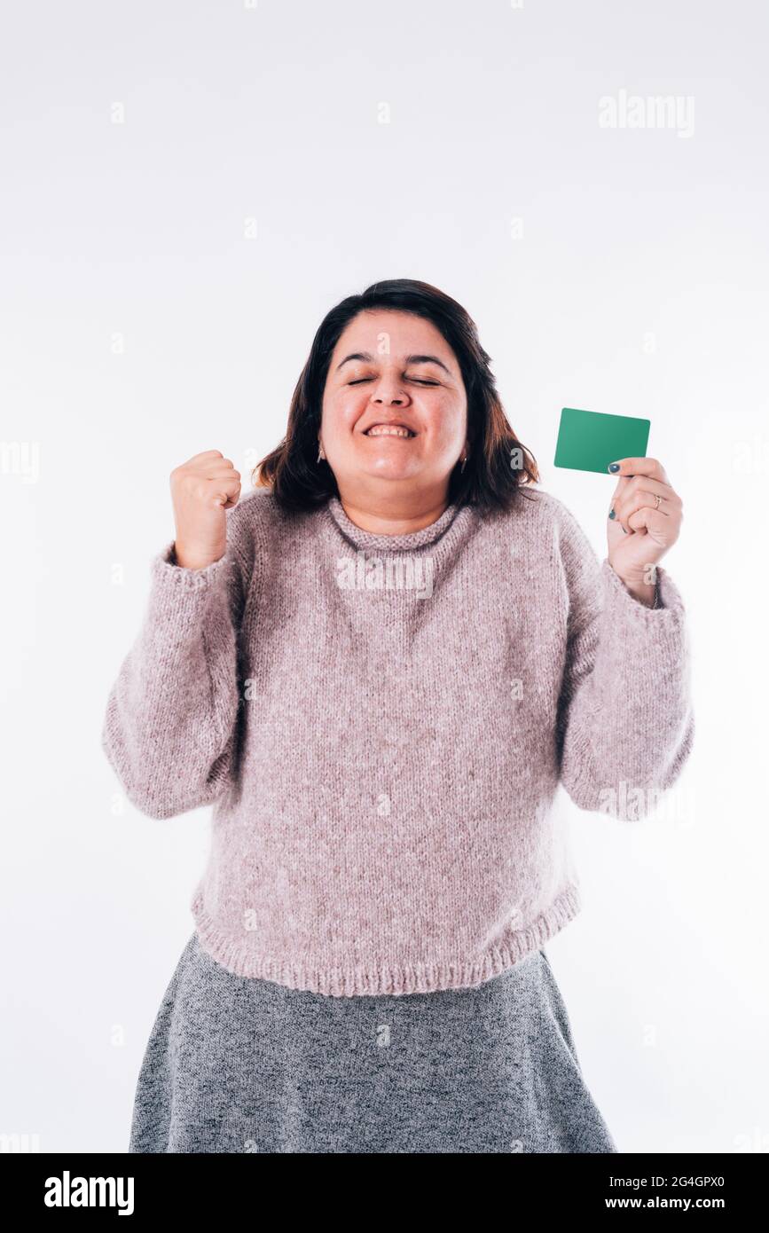 Image verticale d'une femme exagérément heureuse qui se déchèce des yeux avec une carte d'achat en ligne dans sa main. Concept commercial Banque D'Images