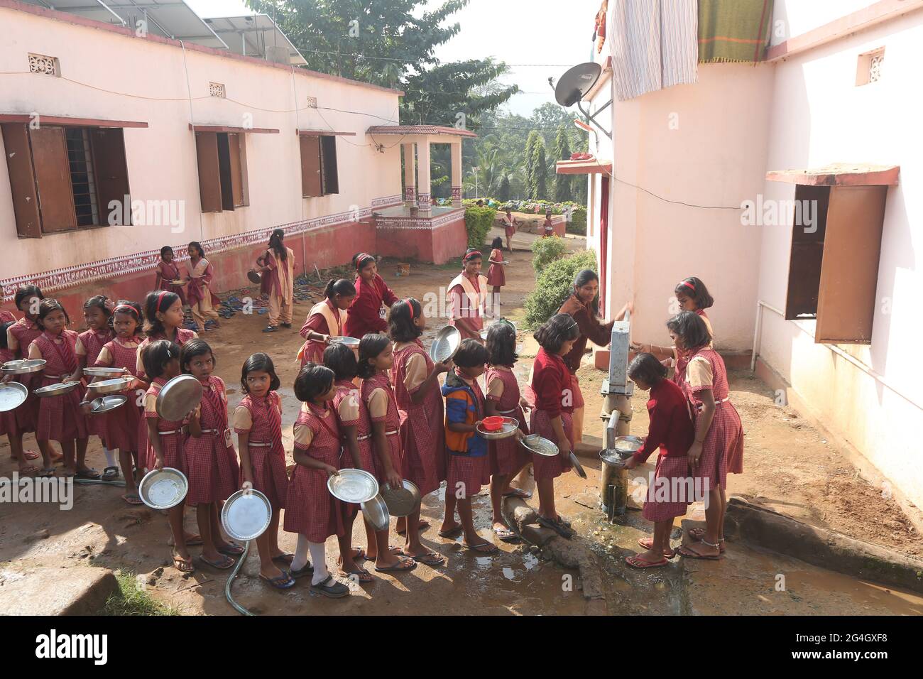 LANJIA SAORA TRIBU. Les filles d'une école tribale du village puttasingh lavent leurs assiettes à un robinet après le repas. Village de Puttasingh à Odisha, in Banque D'Images