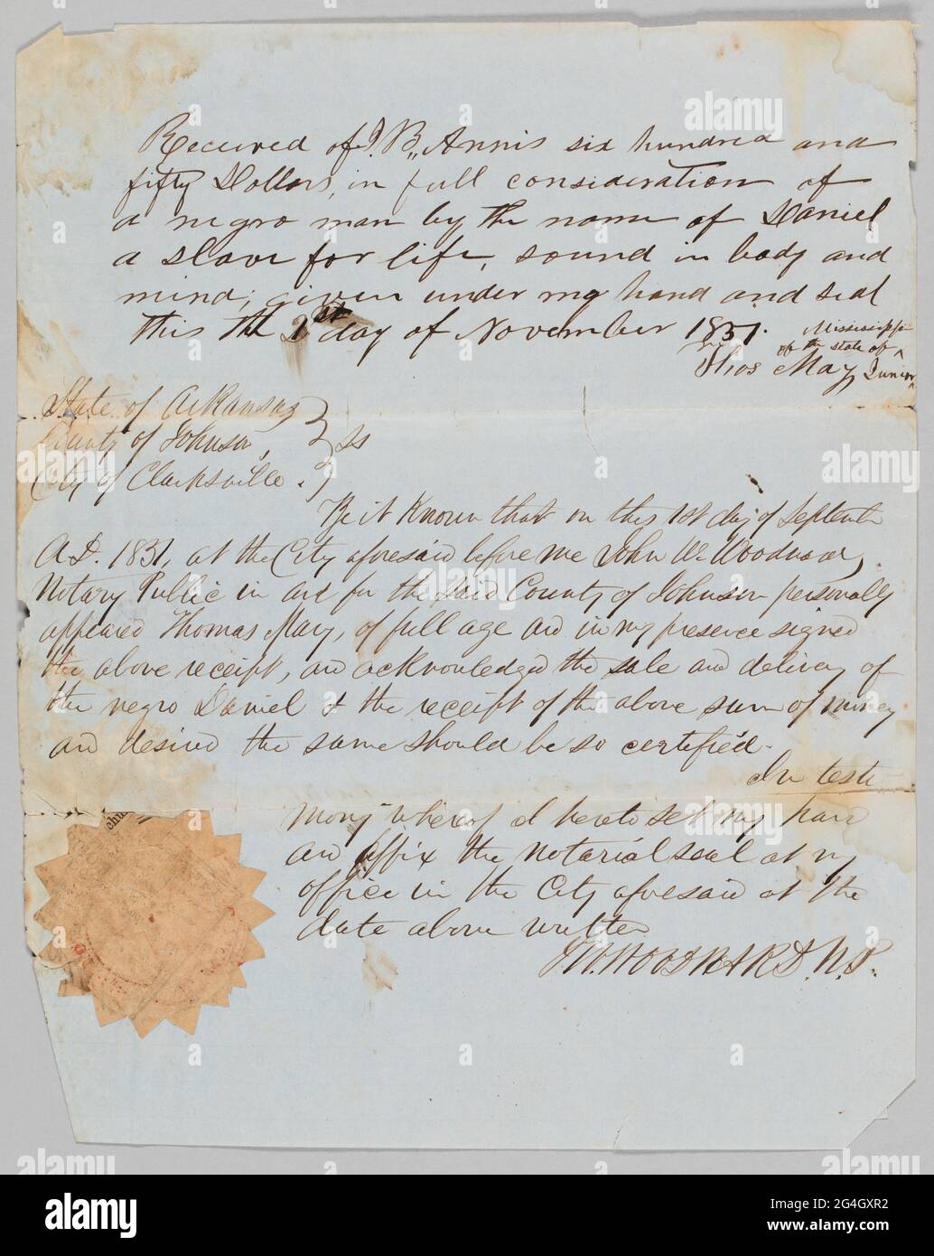 Cet acte de vente détaille la vente d'un homme en esclavage nommé Daniel de Thomas May à Jerome B. Annis. Le papier était précédemment plié en trois, laissant des plis profonds sur la page. Au dos du papier, les mots [acte de vente / pour esclave nommé / Daniel / Date / 2nd / Nov 1851] sont écrits au crayon. Le papier est doublé et a une teinte bleuâtre. Thomas May a écrit le reçu et John W. Woodward, notaire public, a assisté à la vente et a signé au bas de la page [J. W. WOODWARD. N.P.]. Le sceau du notaire du comté de Johnson, Arkansas, est fait de journal et est apposé à la page en t Banque D'Images