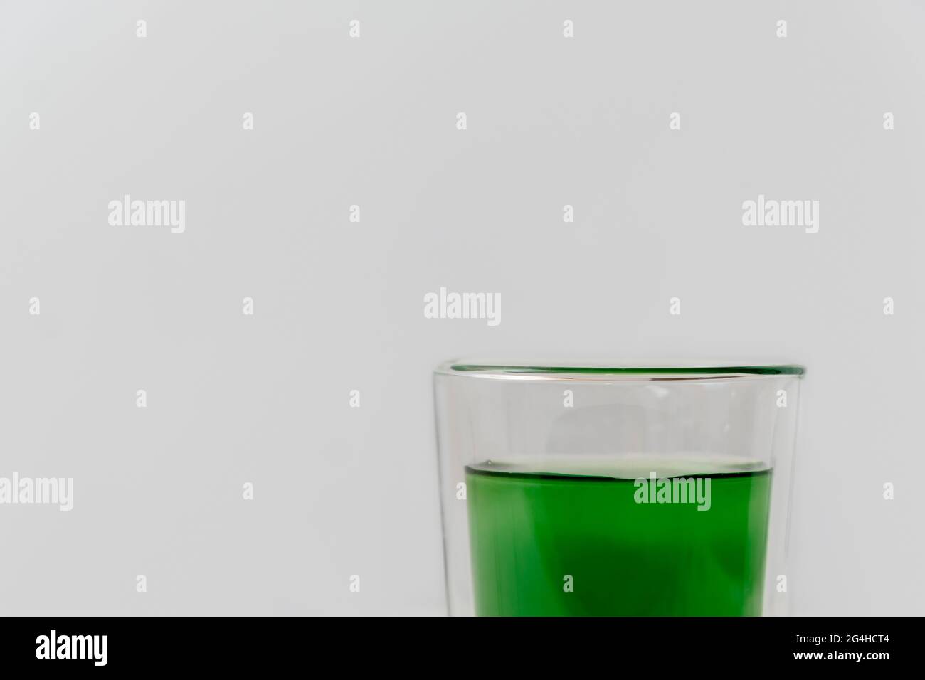 Buvez de l'extrait de chlorophylle liquide avec une tasse d'eau sur fond blanc avec espace de copie Banque D'Images