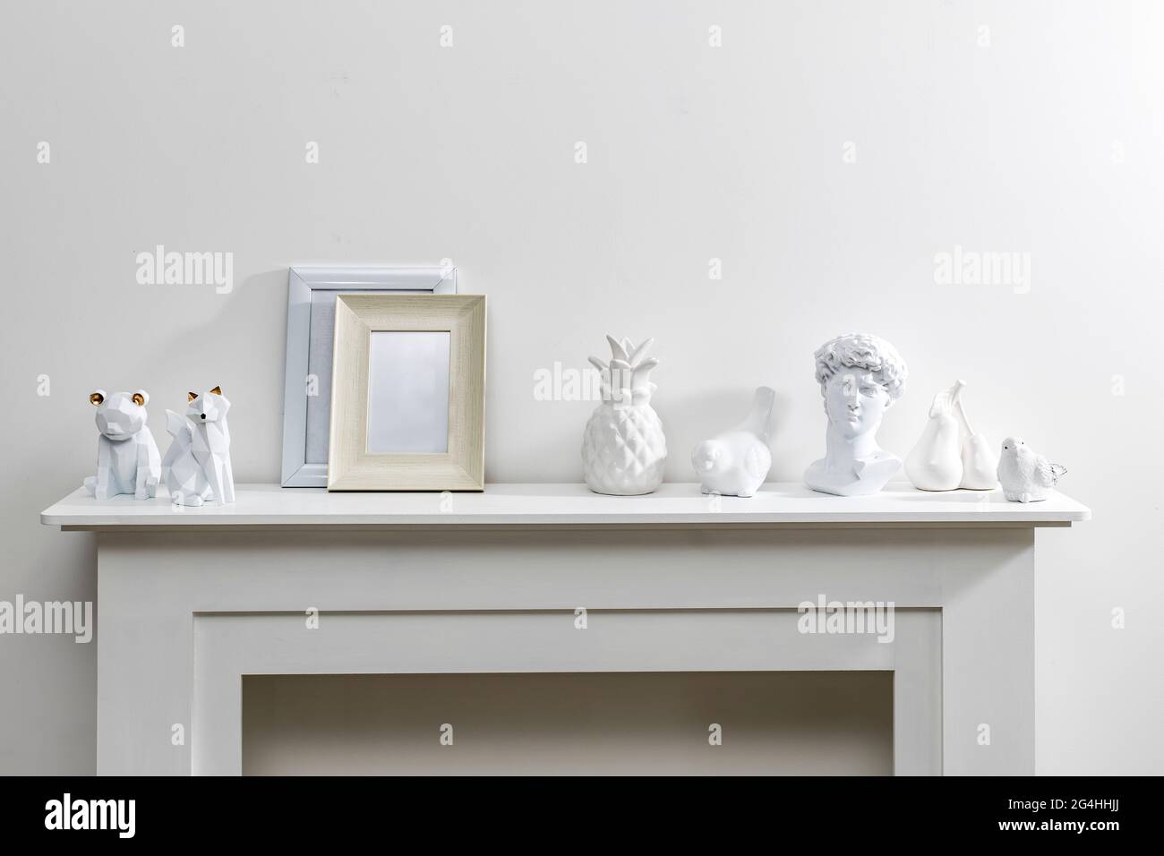 Ensemble de maquettes dorées pour cadres de portrait. Figurines d'ours, renard sur la surface de la commode. Fond de mur blanc. Boho exotique intérieur des Banque D'Images