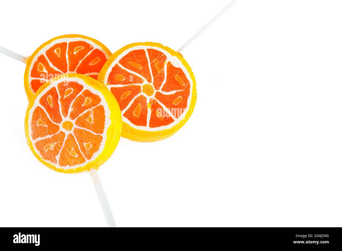 Sucreries aromatisées à l'orange sur un bâton. Bonbons orange sur fond blanc. Banque D'Images