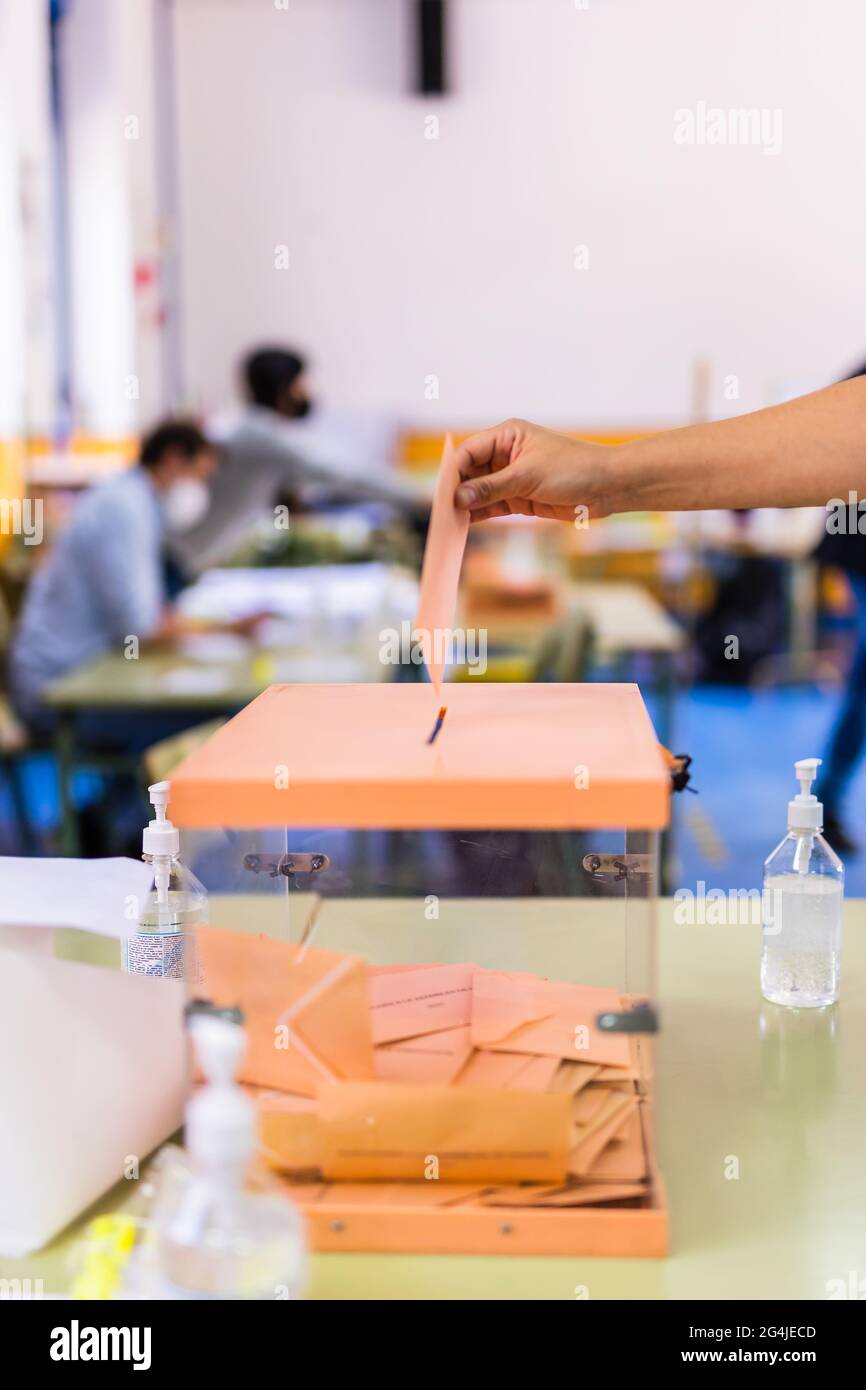 Communauté autonome des élections de Madrid. Référendum démocratique pour le vote du gouvernement. Main posant une enveloppe dans une urne pour les élections communautaires Banque D'Images