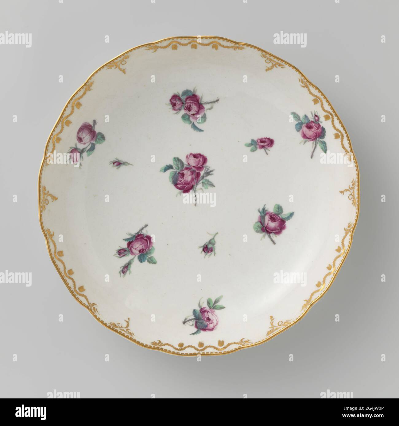 Écaillé, peint avec des roses éparses. Echelle de porcelaine. Bordure festonnée avec motifs rumeur en relief, qui sont partiellement plaquées, partiellement recouvertes de guirlandes de feuilles en or. Les Bies avec feuilles dépendantes travaillent en or sur le bord. Peint avec des roses éparses dans la rose, le vert, le bleu et le gris. Banque D'Images