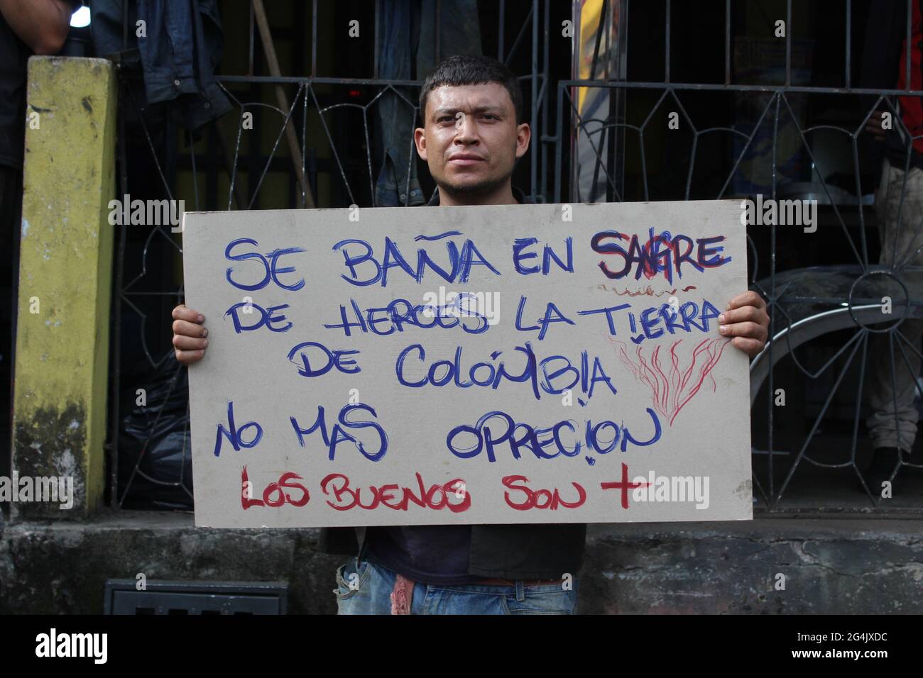 Un manifestant porte un signe qui lit « le sang des héros colombiens qui  traversent le sol colombien, plus d'oppression » comme des milliers de  paysans, indigènes et de personnes engagées dans