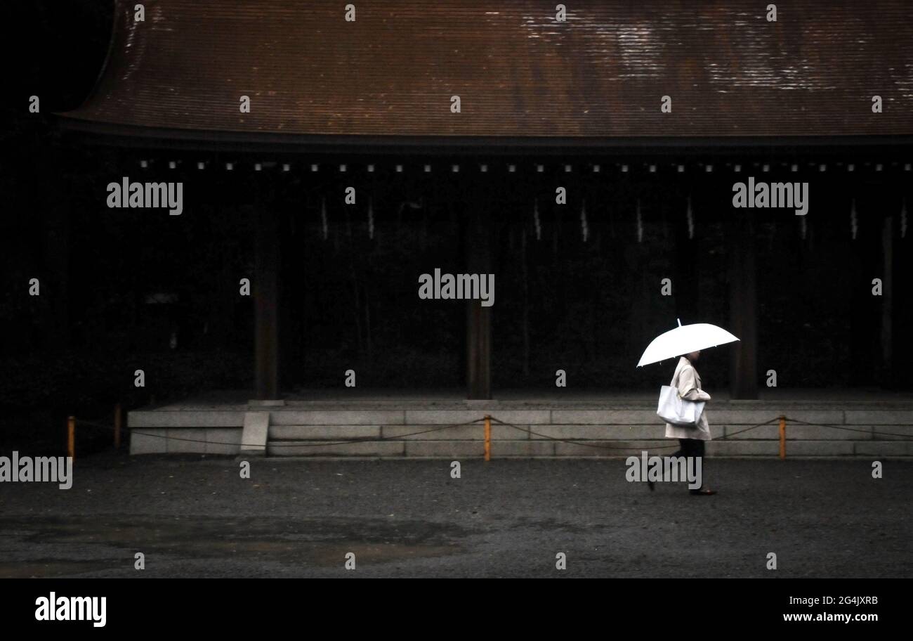 Fille avec parapluie blanc marchant dans le sanctuaire Meiji Jingu à Tokyo, Japon Banque D'Images