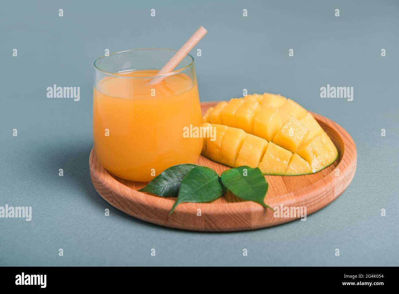 Verre de jus d'orange et de mangue et tranche d'orange fruits sur un bureau en bois Banque D'Images
