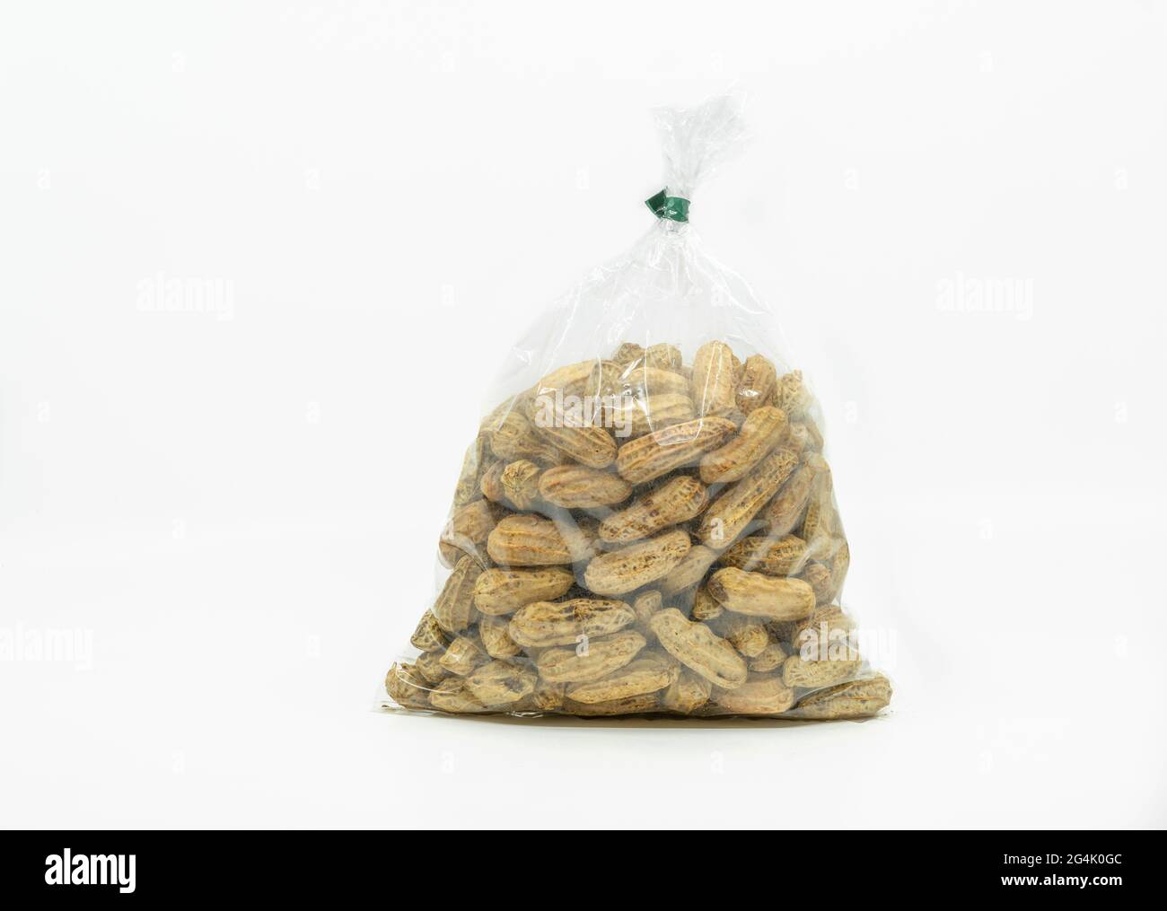 Gros plan des arachides bouillies dans un sac en plastique transparent à vendre sur le marché, prêt à manger, image solée sur fond blanc, vue avant du sac. Banque D'Images