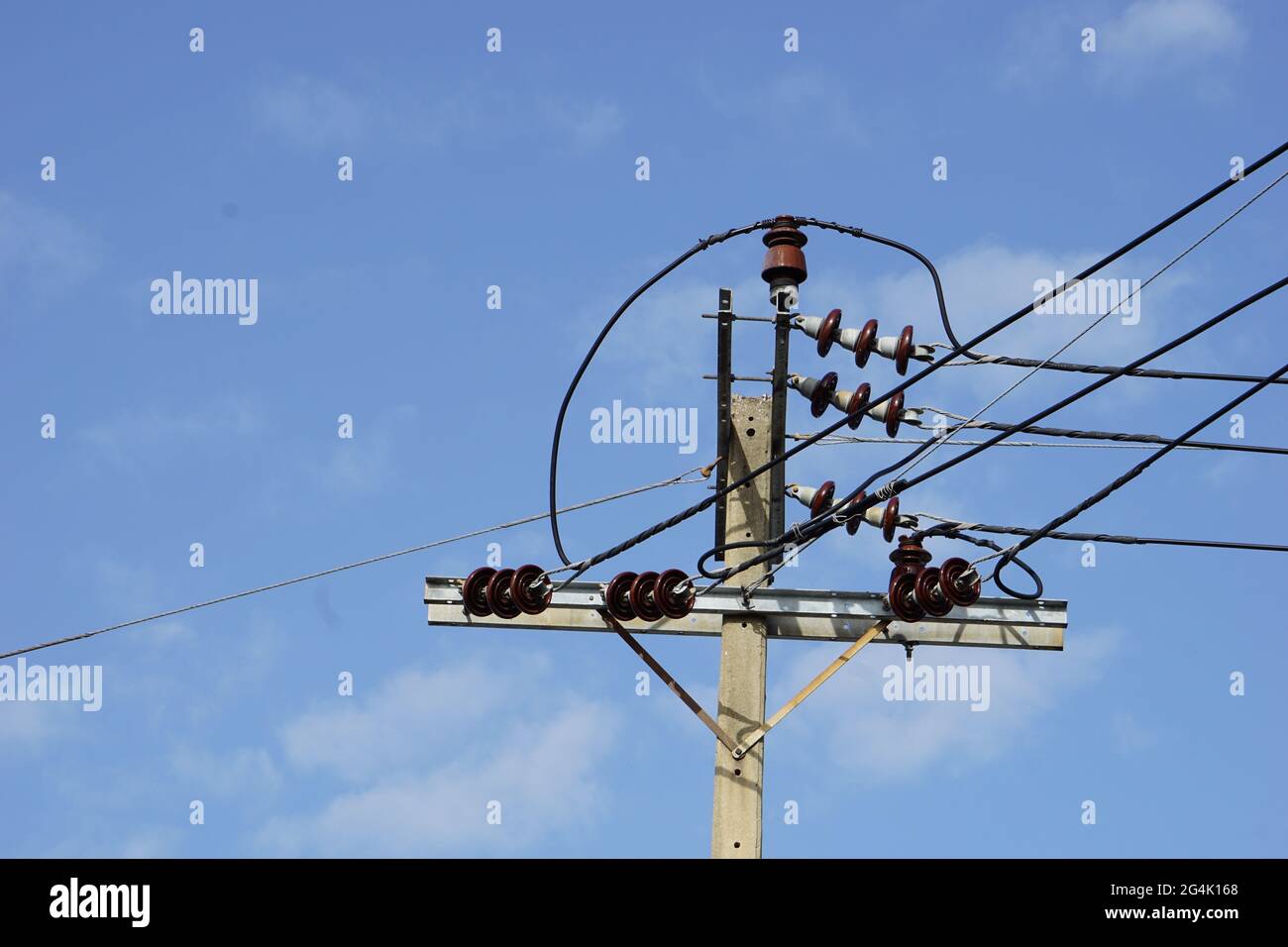 pôle haute tension sur fond bleu ciel blanc nuages Banque D'Images