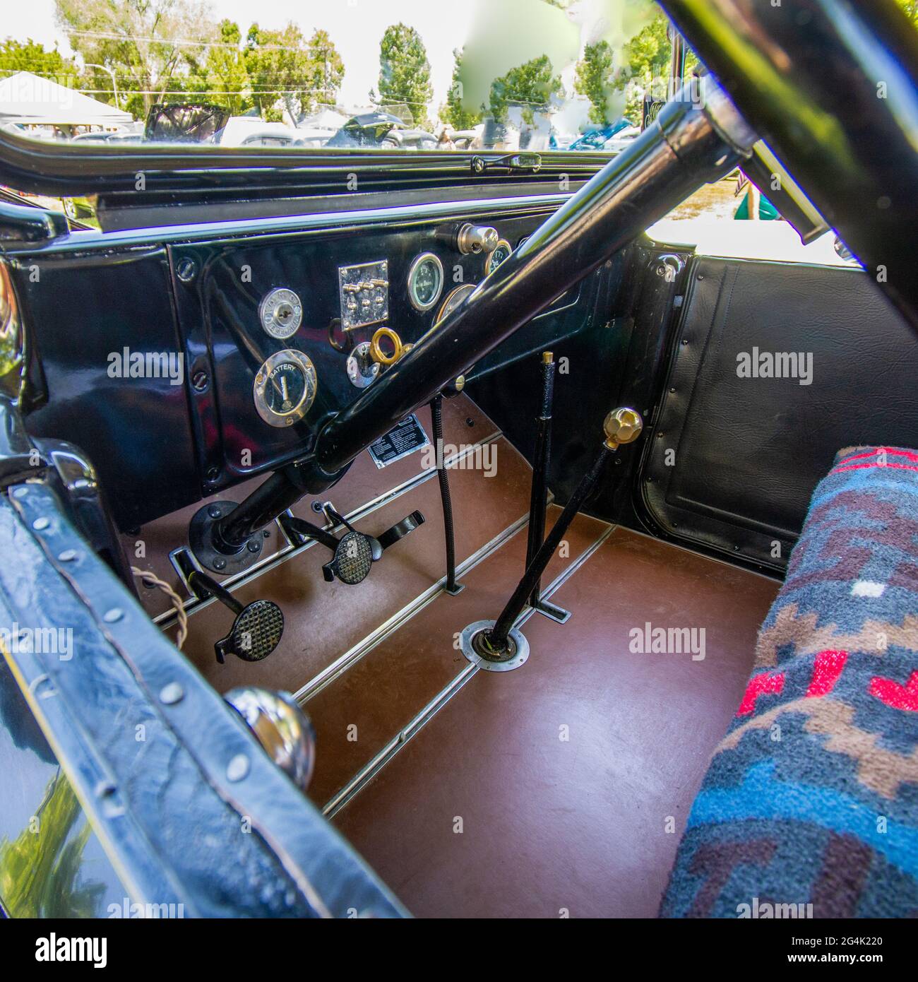 Vue à l'intérieur d'une voiture rétro avec la longue tige de volant avec frein et accélérateur Banque D'Images