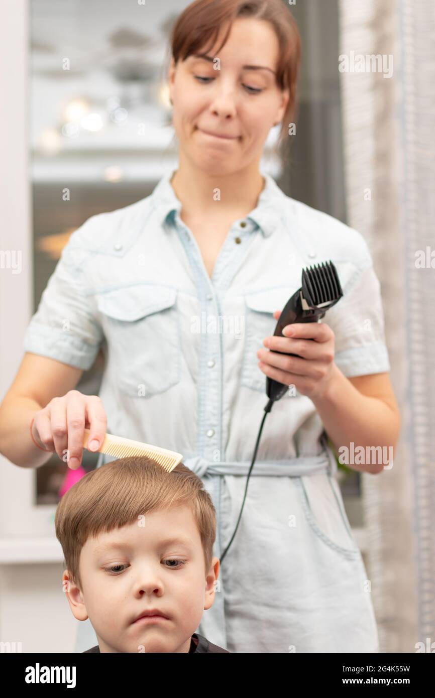Jeune Maman Coiffeur Coupe Son Bebe Garcon A La Maison Avec Une Tondeuse A Cheveux Pendant La Quarantaine Foyer Selectif Portrait Photo Stock Alamy