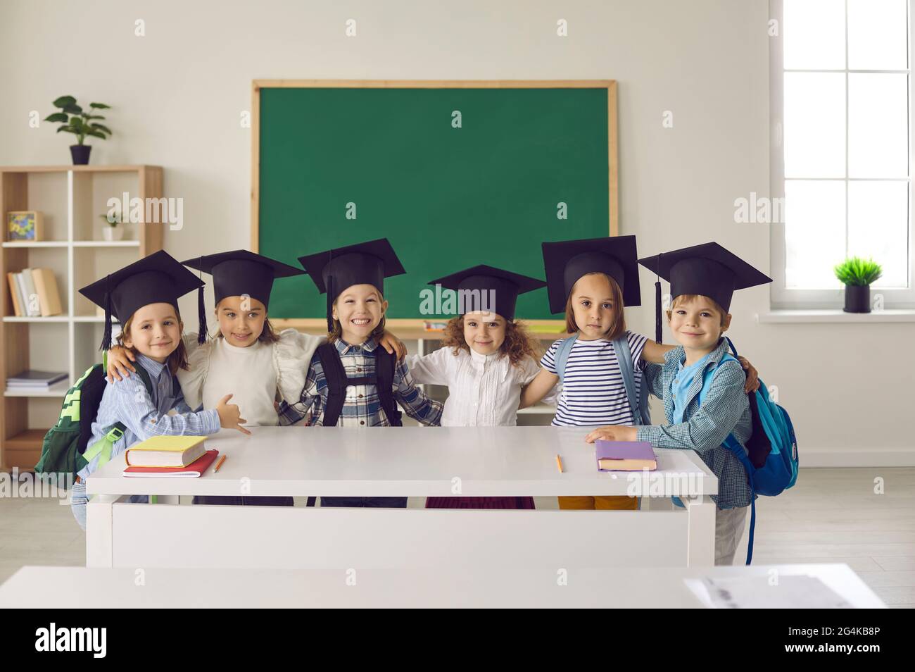 Portrait d'un groupe de diplômés de la classe maternelle ou junior en chapeau de Bachelor ou en mortaboard. Banque D'Images
