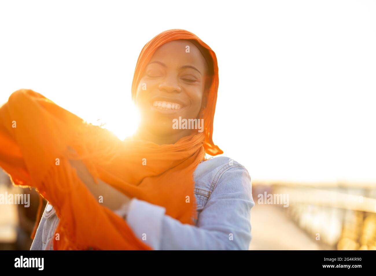 Jeune femme en hijab à l'extérieur au coucher du soleil Banque D'Images