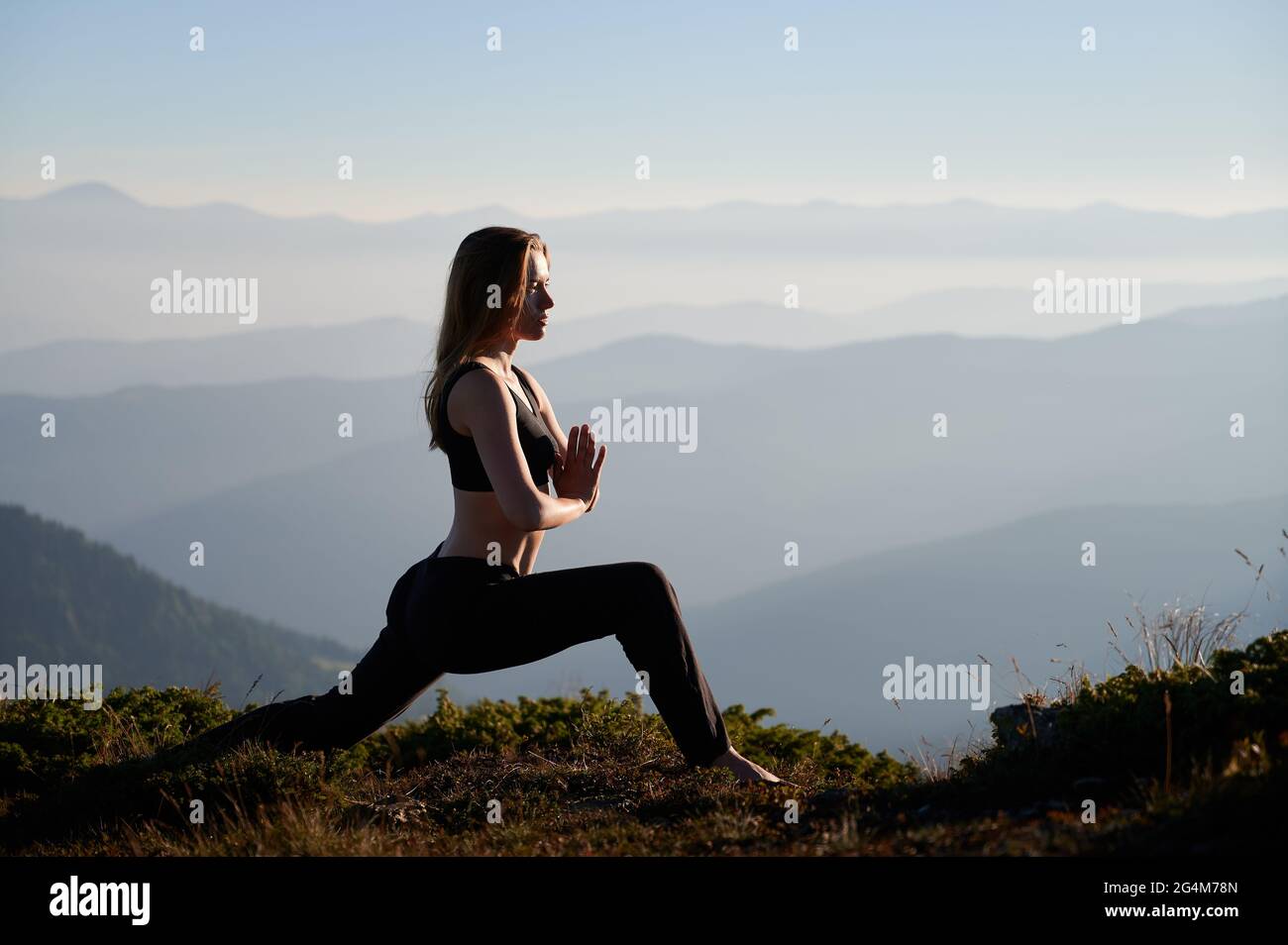 Vue latérale d'une jeune femme sportive qui fait de l'exercice en plein air. Concept de nature incroyable. Banque D'Images