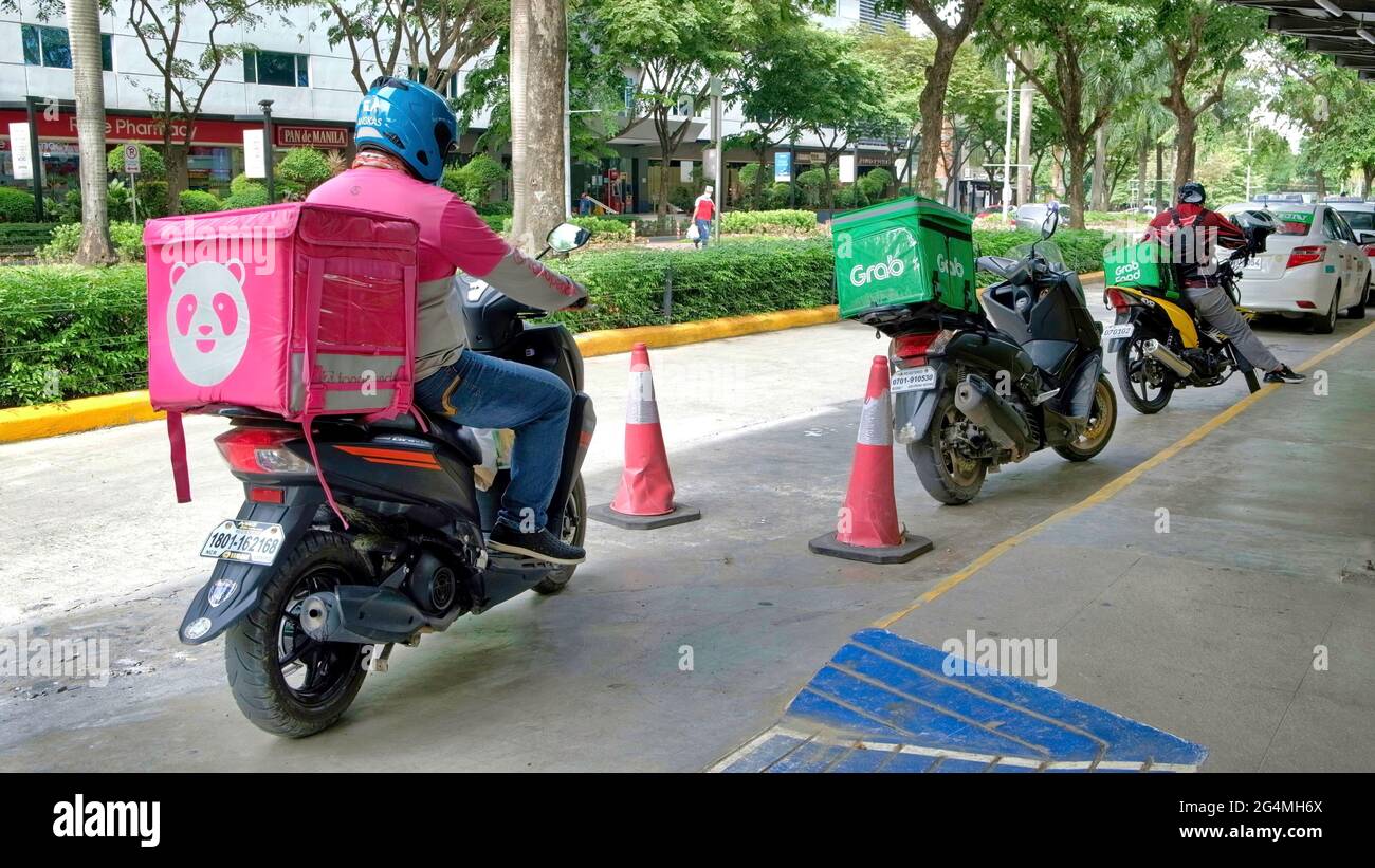 Cebu City, Philippines ; 22 juin 2021 -- scène pandémique commune d'un chauffeur de livraison de nourriture se dépêchant d'apporter de la nourriture commandée à un client dans cette ville. Banque D'Images