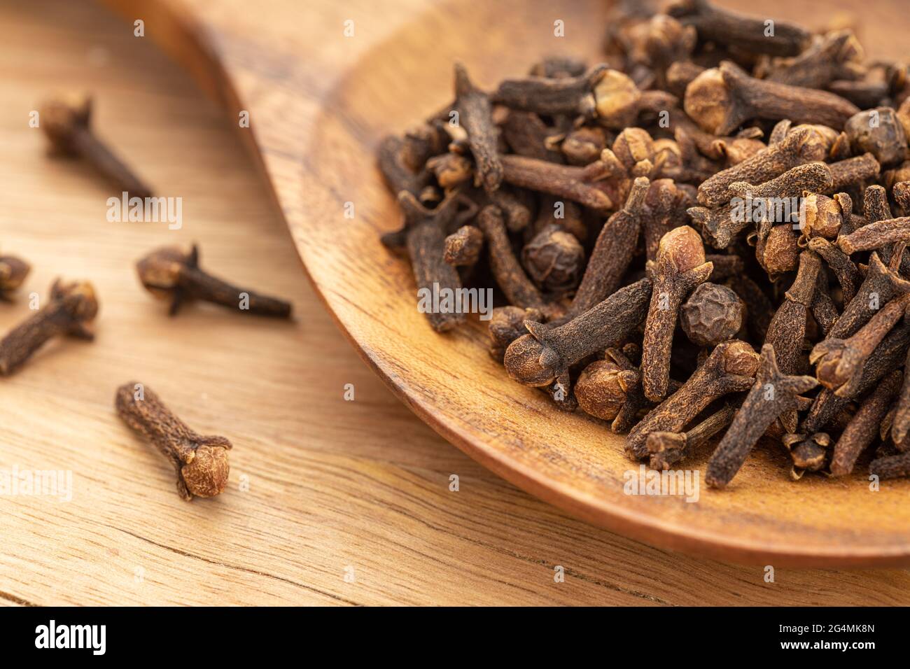 Clous de girofle sur une cuillère en bois. Cuisson des épices. Syzygium aromaticum Banque D'Images Clous de girofle sur une cuillère en bois. Cuisson des épices. Syzygium aromaticum Banque D'Images