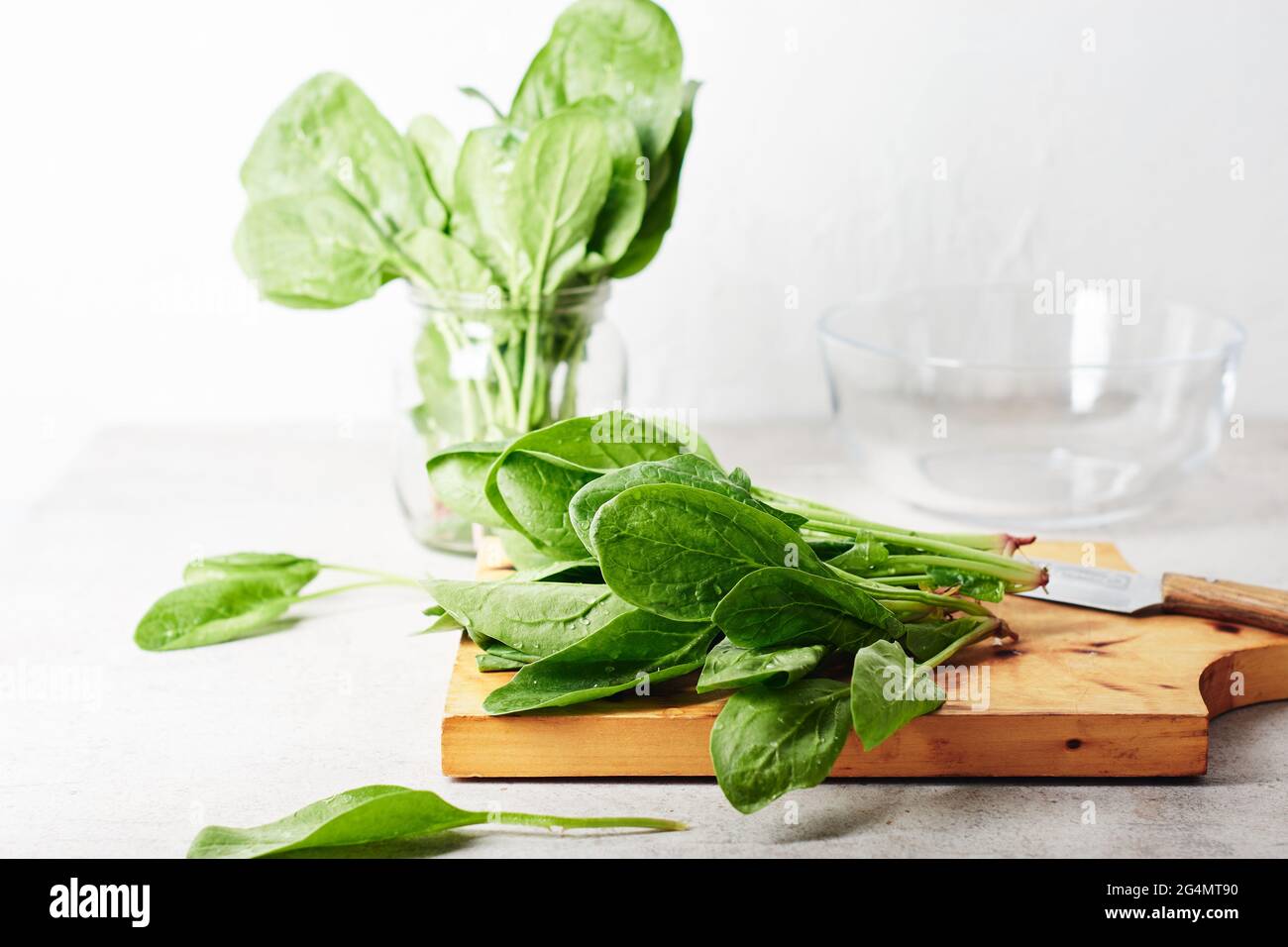 Feuilles d'épinards verts frais sur une planche à cuisine. Banque D'Images