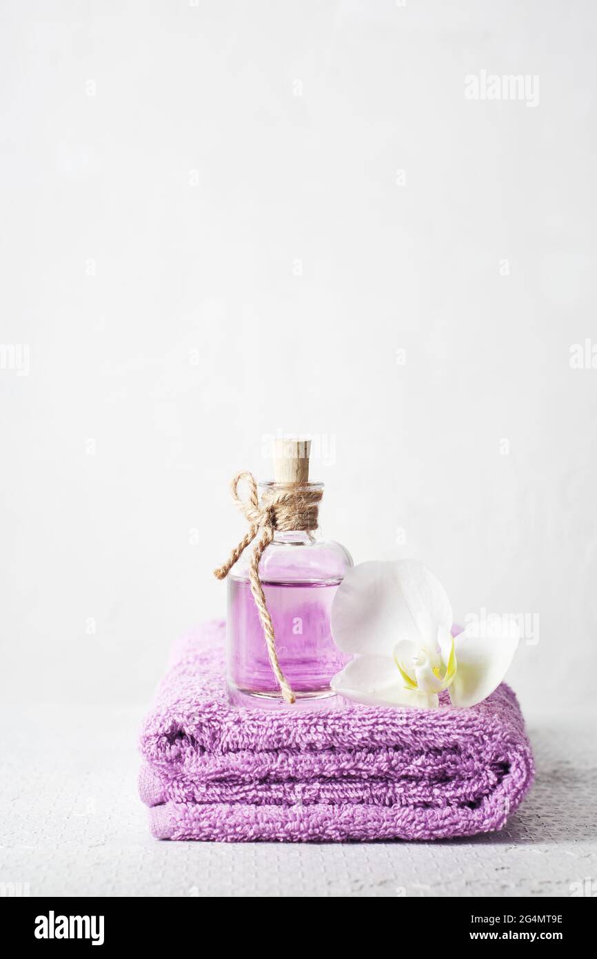 Une bouteille de parfum lilas et de fleurs d'orchidées. Produits cosmétiques aromatiques, soins de spa. Banque D'Images