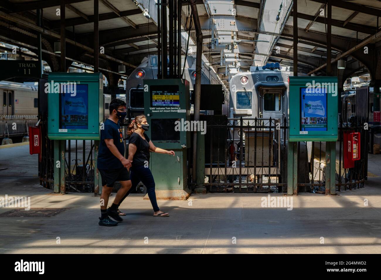 Hoboken, NJ, États-Unis — 19 juin 2021. Couple tenant la main marche à travers la gare de hoboken, NJ. Banque D'Images