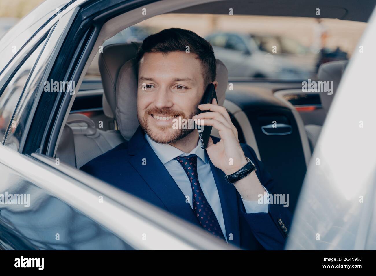 Le directeur de la société entend de bonnes nouvelles par téléphone en voiture Banque D'Images