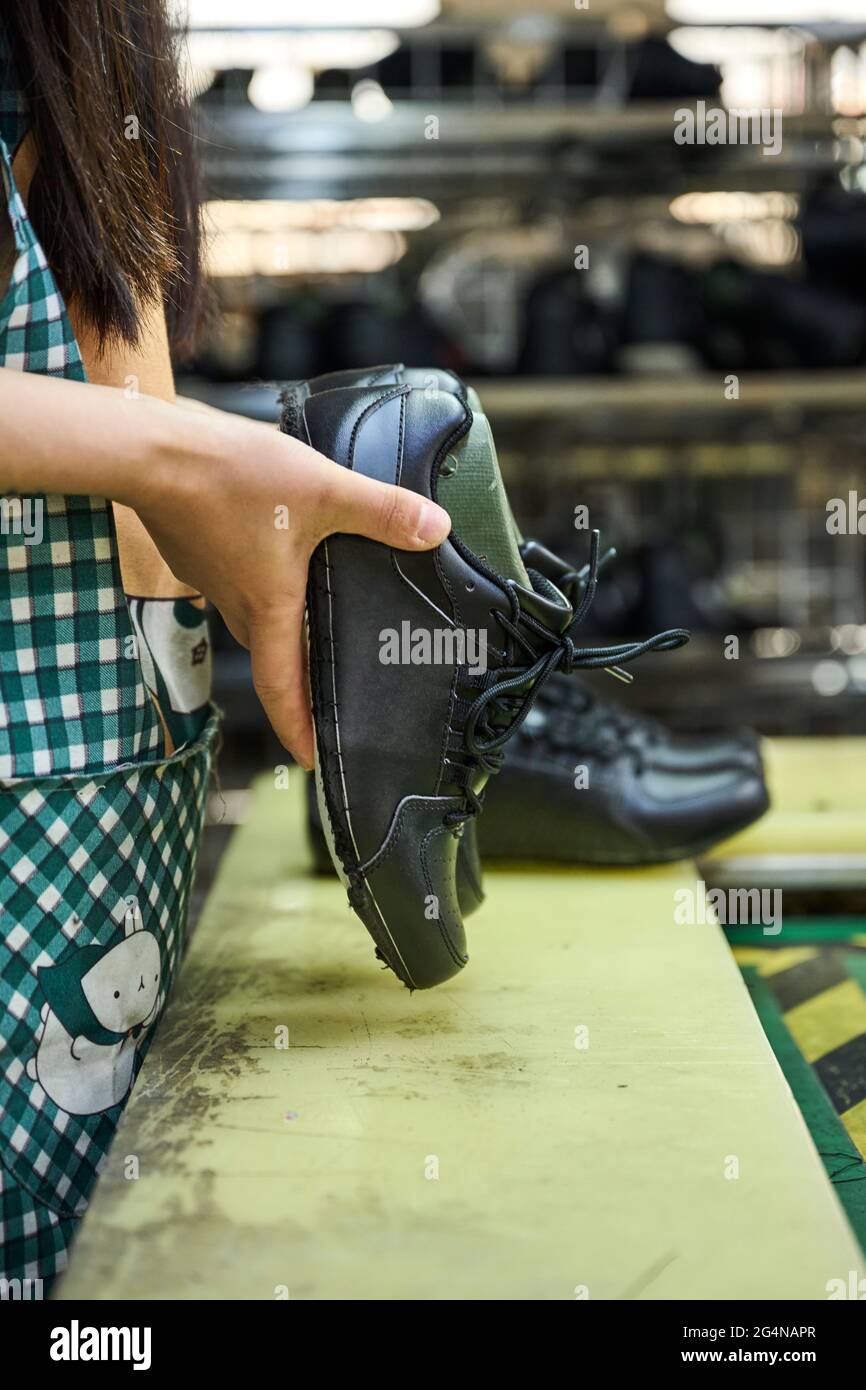Détail des mains de la femme tout en vérifiant les chaussures dans la  chaîne de production de contrôle de qualité dans l'usine chinoise de  chaussures Photo Stock - Alamy