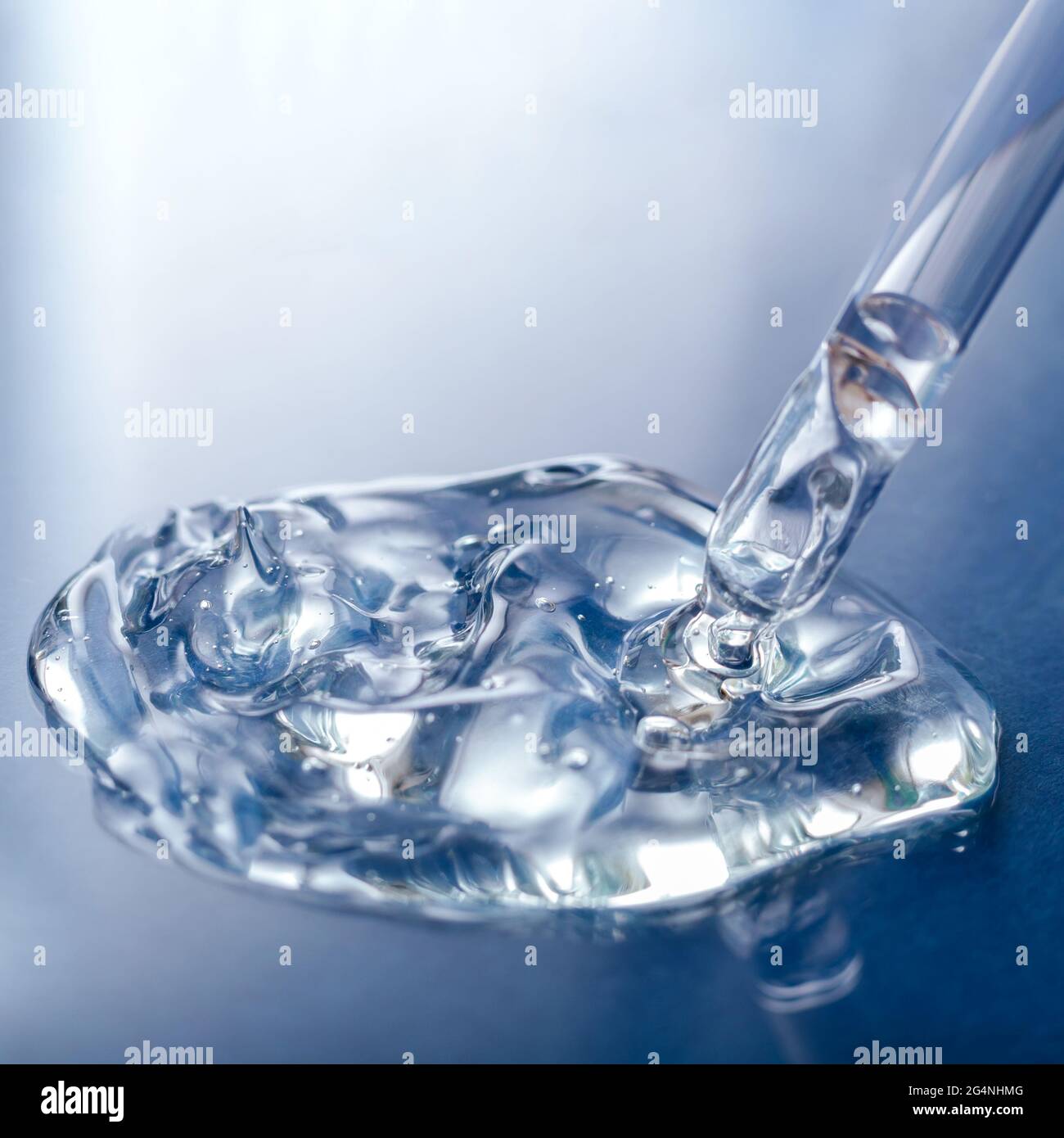 Échantillon de sérum liquide transparent avec pipette sur fond de verre bleu. Produit cosmétique pour les soins de la peau ou gel liquide transparent médical. Carré Banque D'Images