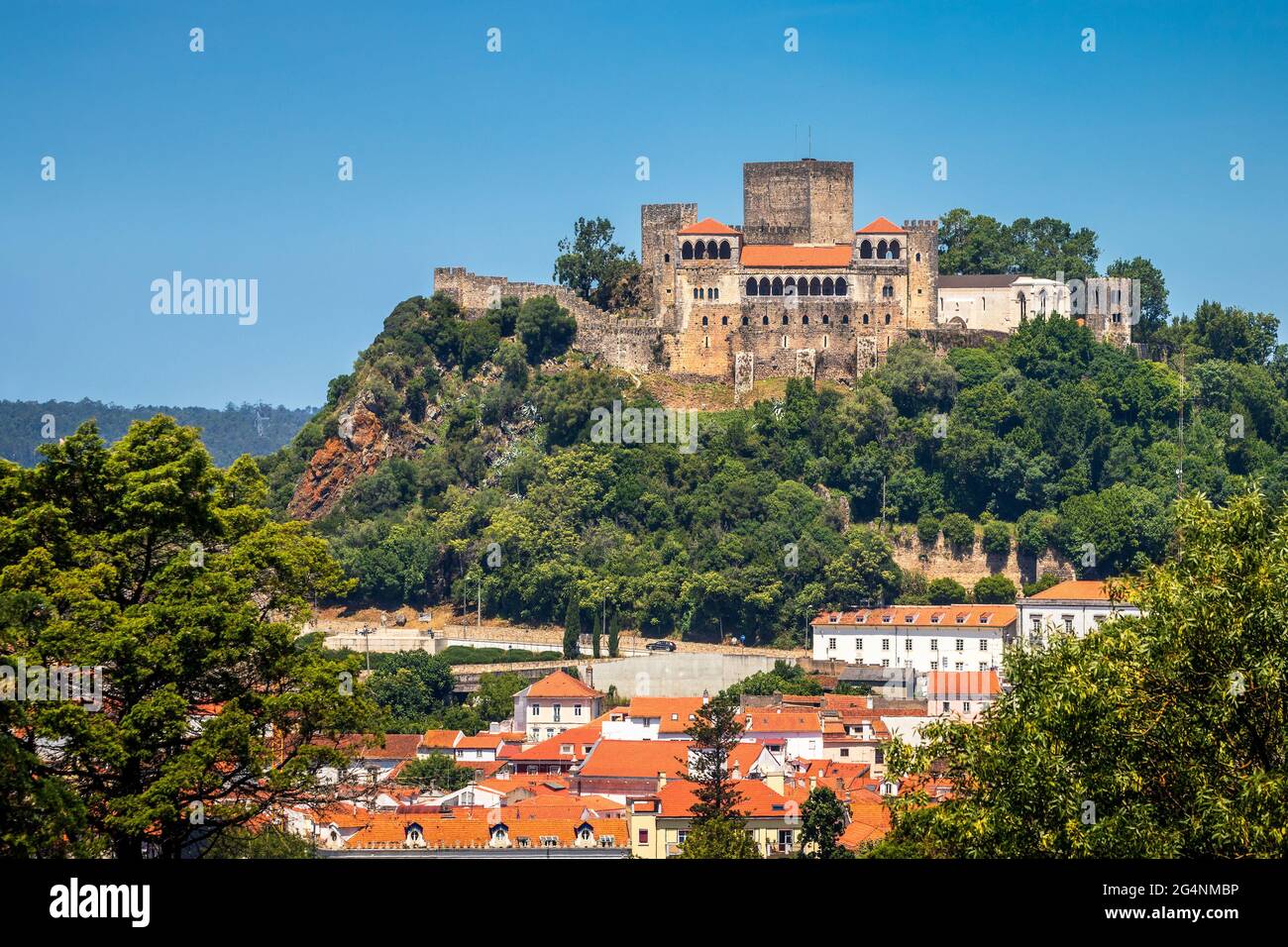 Façade principale du château de Leiria au Portugal, en pleine journée ensoleillée avec ciel bleu, avec quelques bâtiments à la base de sa colline. Banque D'Images