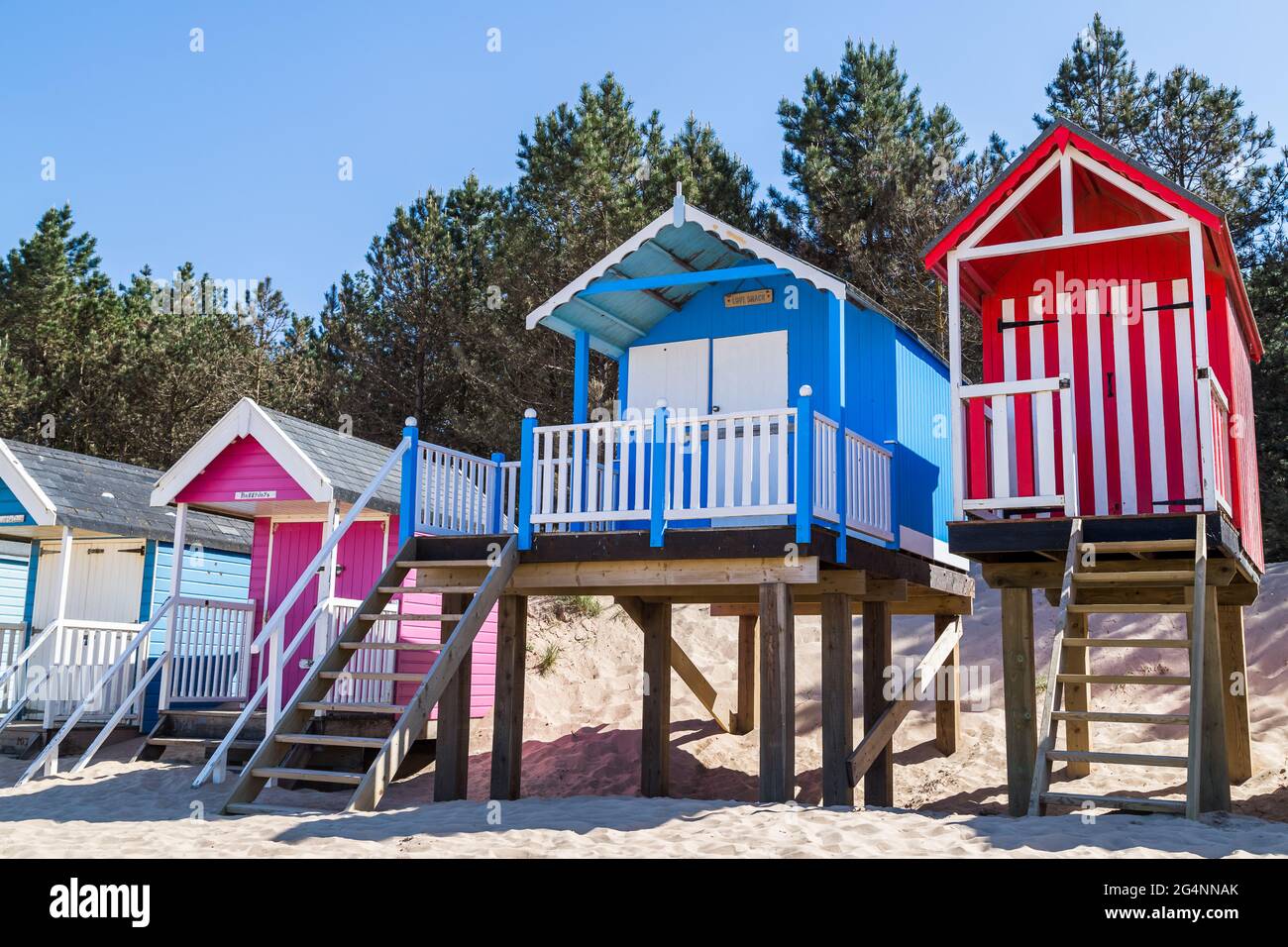 Des cabanes de plage colorées se tenant sur pilotis à Wells près de la mer sur la côte nord de Norfolk en juin 2021. Banque D'Images