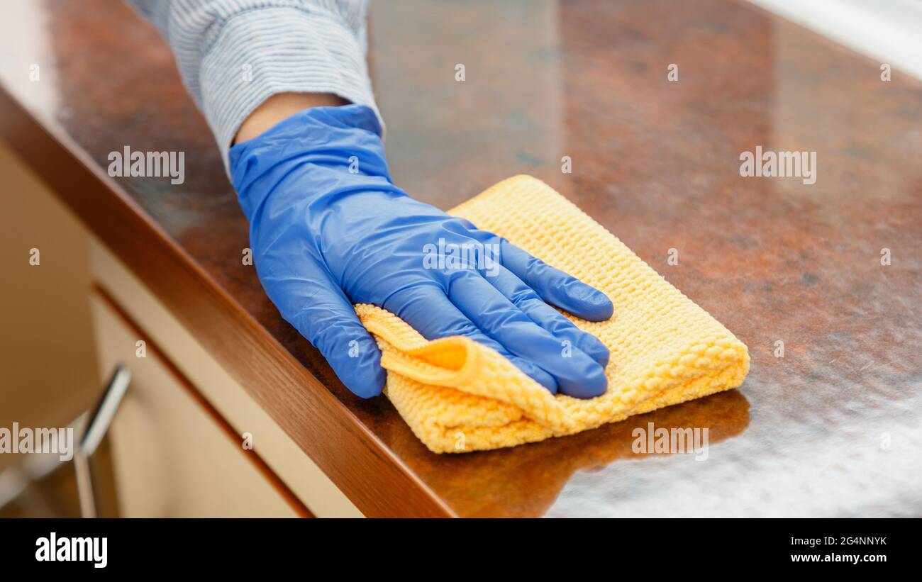Femme essuyant le plan de travail de la table dans la cuisine avec un chiffon humide. Femme charwoman nettoyage des mains désinfecter les surfaces du bureau à la maison du restaurant. Longue bannière Web Banque D'Images