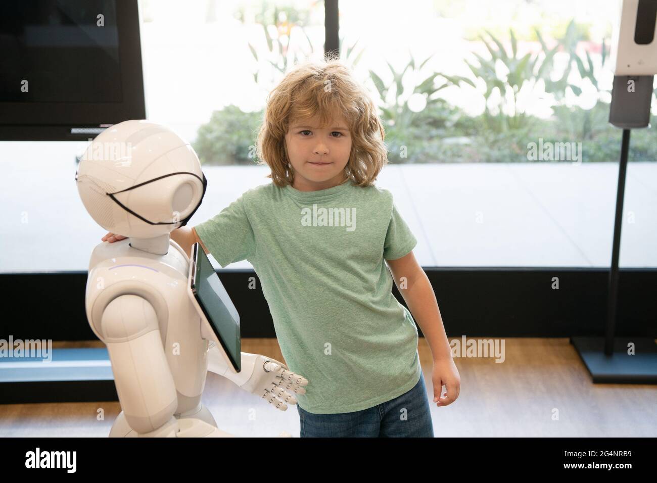assistant d'enfant et de robot avec écran d'information dans le masque de protection. robotique pandémie future Banque D'Images