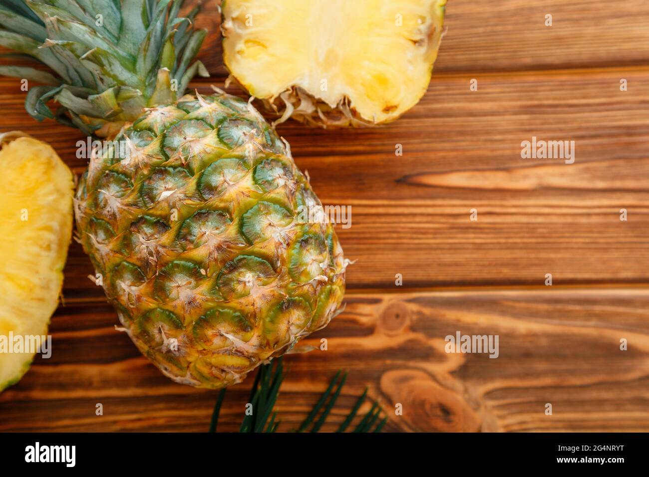 Ananas mûr. Ananas tropical de fruits d'été tranché et ananas entier sur une table en bois brun foncé. Plan de travail avec espace de copie Banque D'Images