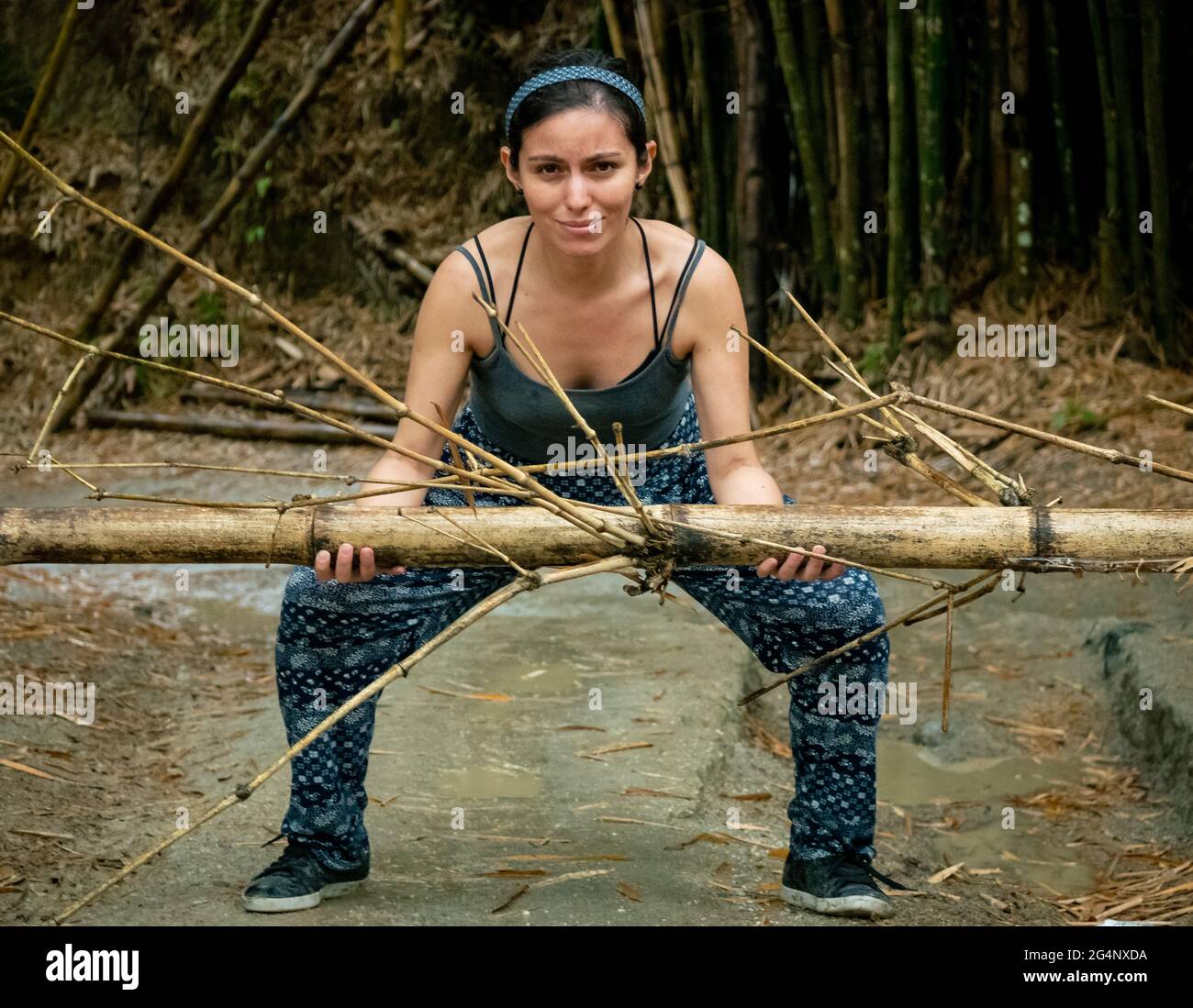 Latino Woman lève un bambou dans une route sèche à Minca, Colombie Banque D'Images