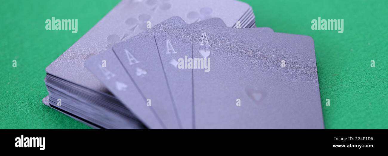 Les cartes à jouer noires avec des as se trouvent sur une table de jeu verte Banque D'Images