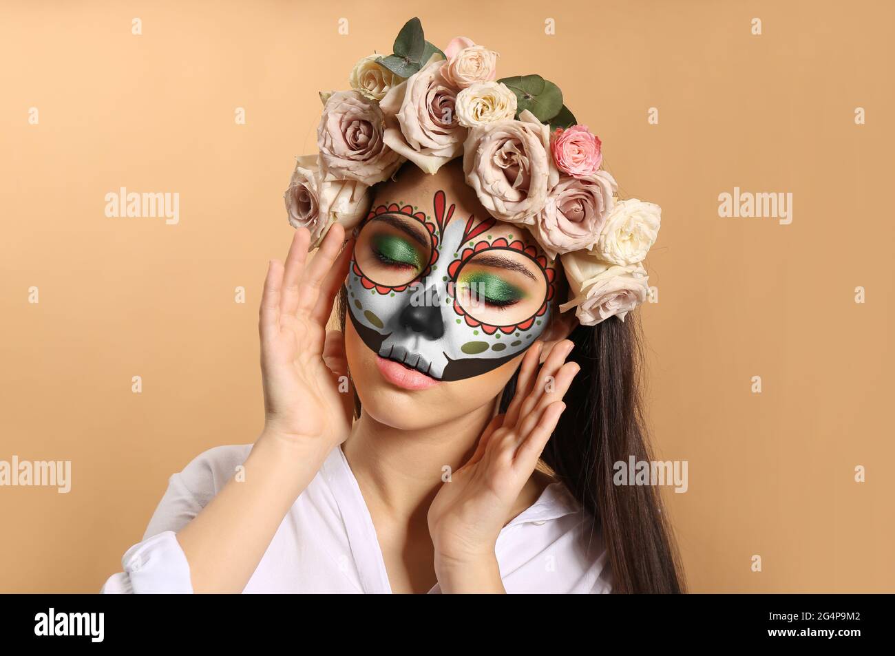 Jeune femme avec crâne peint sur son visage pour le Jour des Morts contre l'arrière-plan couleur Banque D'Images