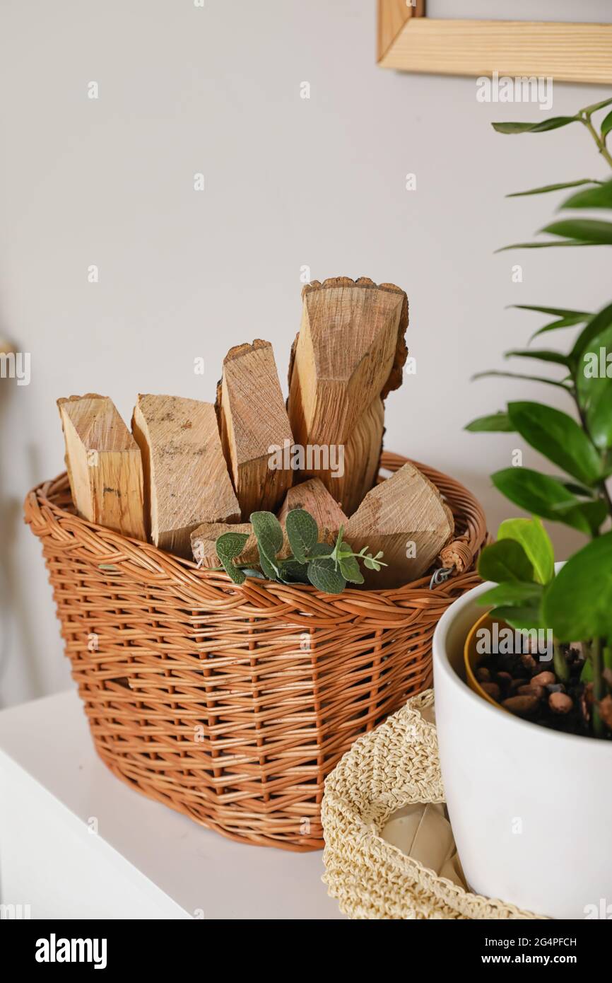Panier avec bois de chauffage sur la tablette près du mur léger Photo Stock  - Alamy