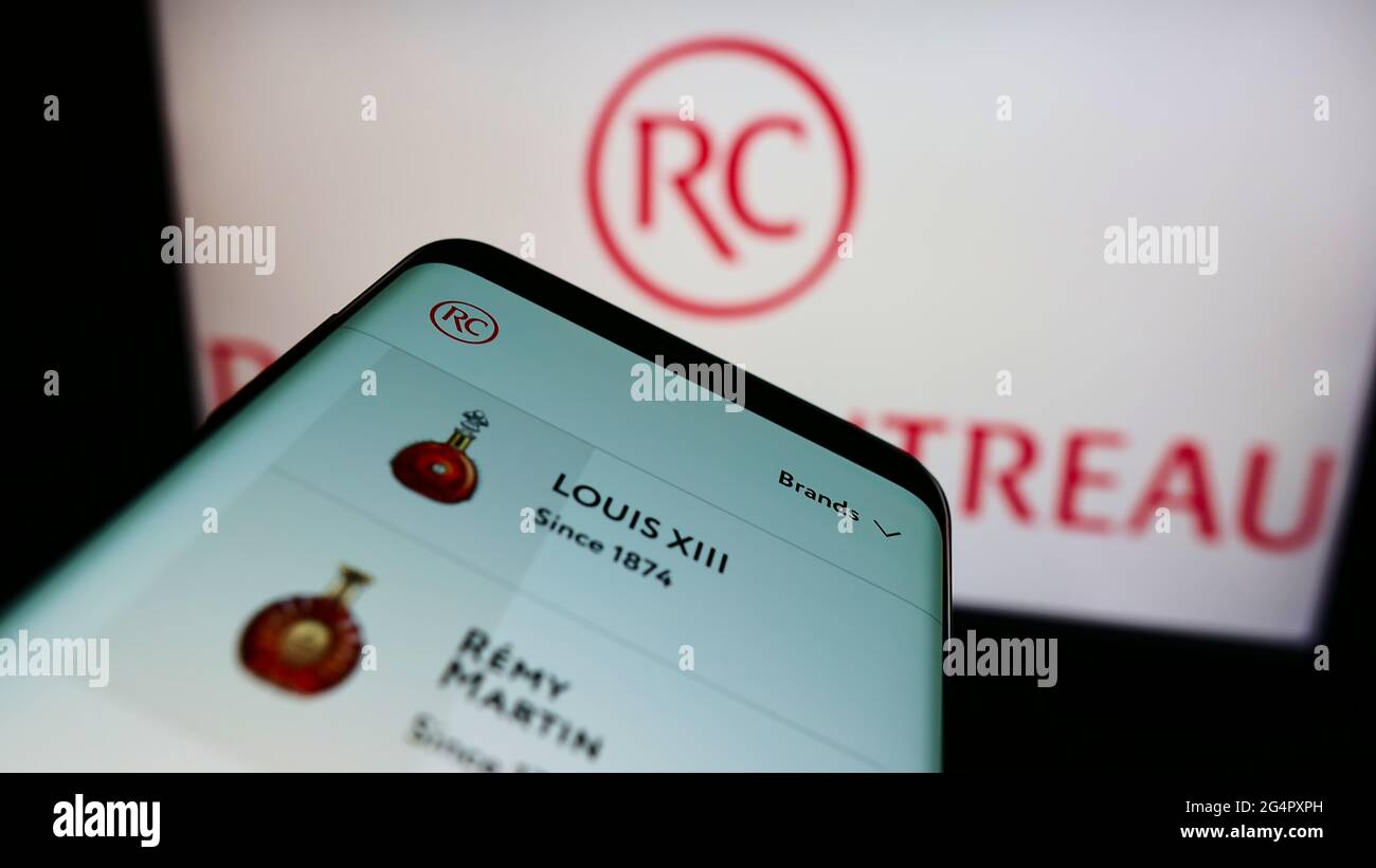Smartphone avec le site Internet de la société française de spiritueux Remy Cointreau S.A. à l'écran devant le logo de l'entreprise. Faites la mise au point dans le coin supérieur gauche de l'écran du téléphone. Banque D'Images