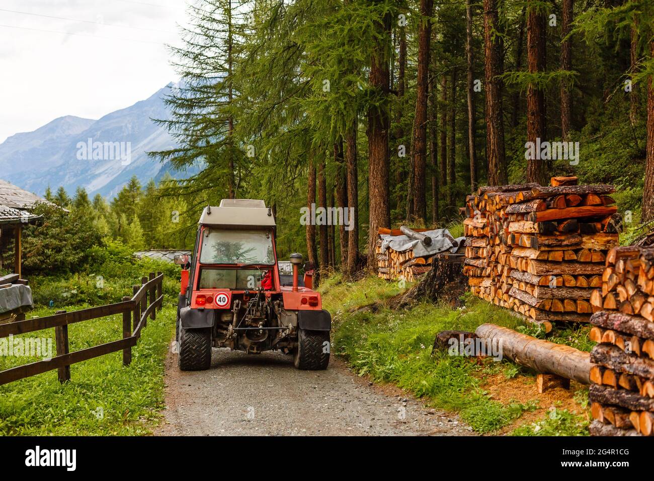 Remorque tracteur improvisés faits maison faite de métal solide empilé avec  bois préparé et recouvert d'une bâche de protection à gauche dans la maison  de famille Photo Stock - Alamy