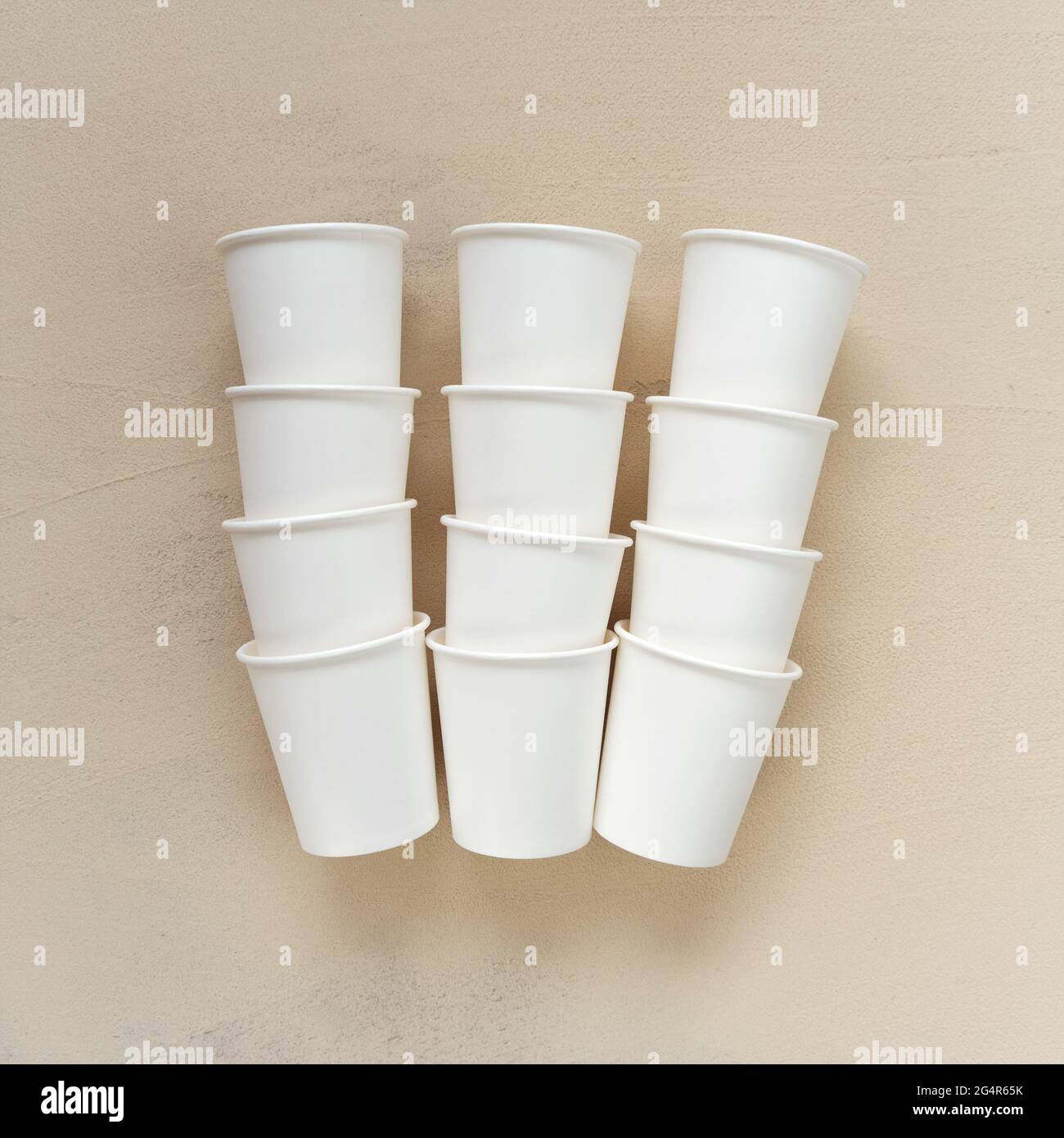 Tasses beiges jetables sur fond beige.tasses en papier biodégradable.vaisselle de paper.plastic tasses bio .Bamboo gratuites. Recyclage écologique Banque D'Images