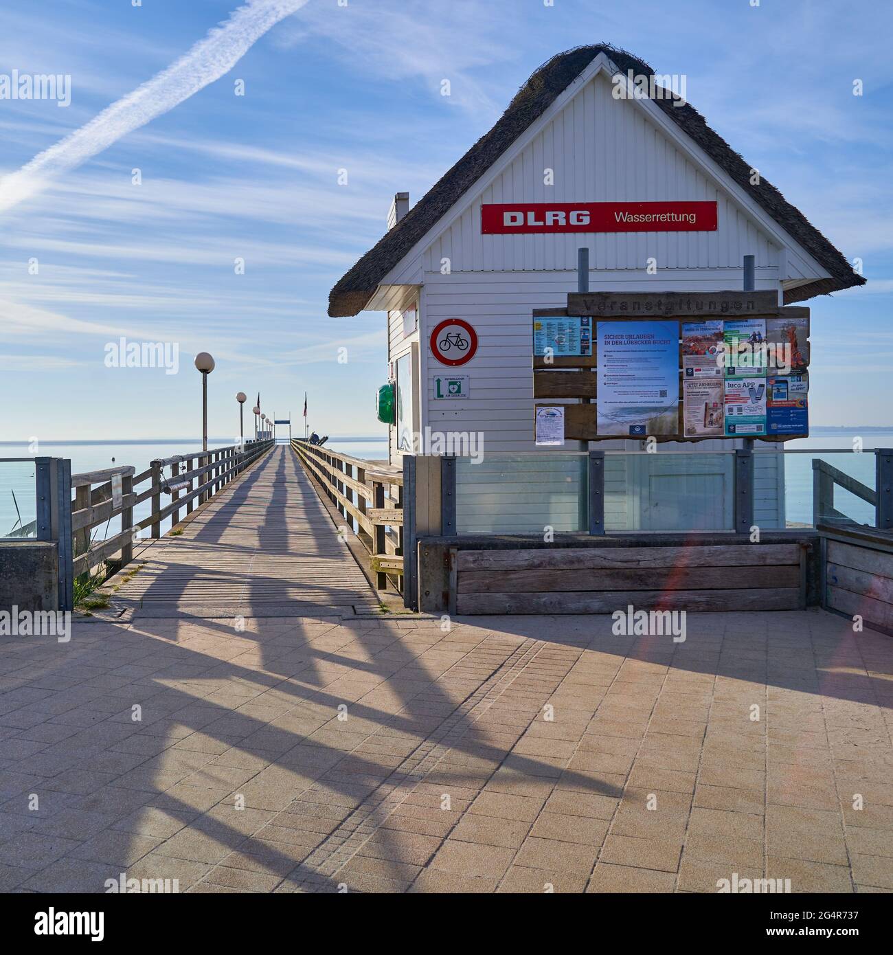 Cabane en bois de DLRG, Société allemande de sauvetage, peinte en blanc, devant un quai sur la plage de la baie de Lubeck, sur la mer Baltique, Travemunde, Allemagne, Ju Banque D'Images