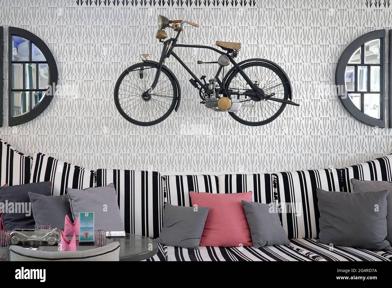 Un vélo motorisé vintage utilisait un objet de curio fixé au mur dans un restaurant moderne Banque D'Images