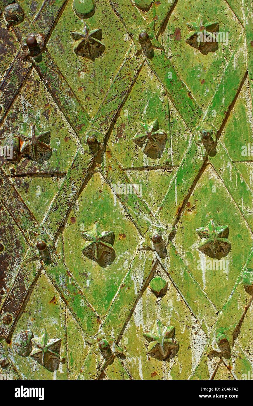 Fragment d'un ancien métal médiéval en fer forgé porte fiable avec des figures décoratives, peintes en plusieurs couches principalement dans des tons de vert Banque D'Images