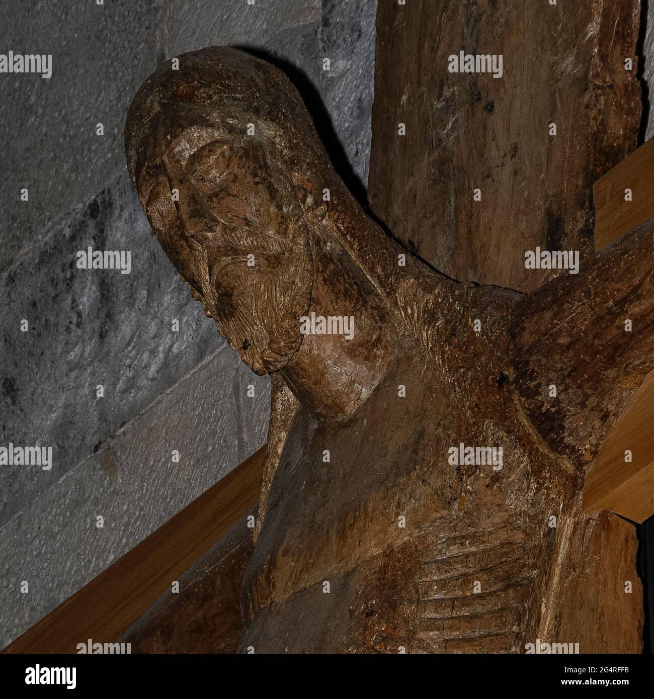 Vue rapprochée sur la place d'un chef-d'œuvre de la sculpture religieuse médiévale, un crucifix sculpté dans le milieu des années 1100s à partir d'un tronc de peuplier massif, avec les bras ajoutés dans le bois d'aulne, suspendu dans la Chiesa di Santa Maria del Tiglio, Ancien baptistère roman sur les rives du lac de Côme à Gravedona, Lombardie, Italie. Bien qu'il puisse être lombardique, il est plus typique de la sculpture française ou allemande et un crucifix semblable en bronze est conservé au monastère bénédictin werden près d'Essen dans la Ruhr, en Allemagne. Banque D'Images