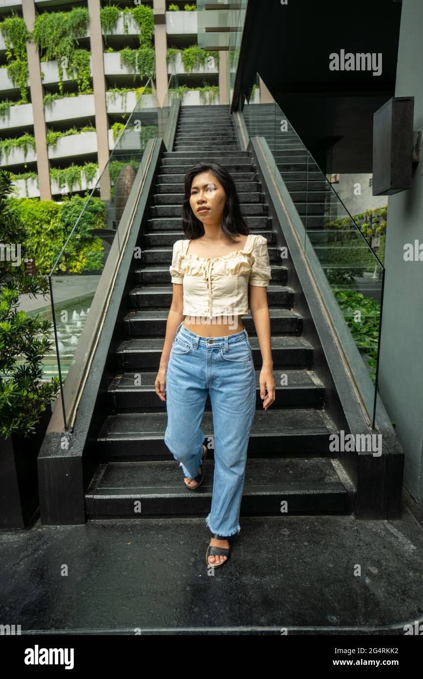 Fille asiatique en ville par le mur de graffiti et dans un café Banque D'Images