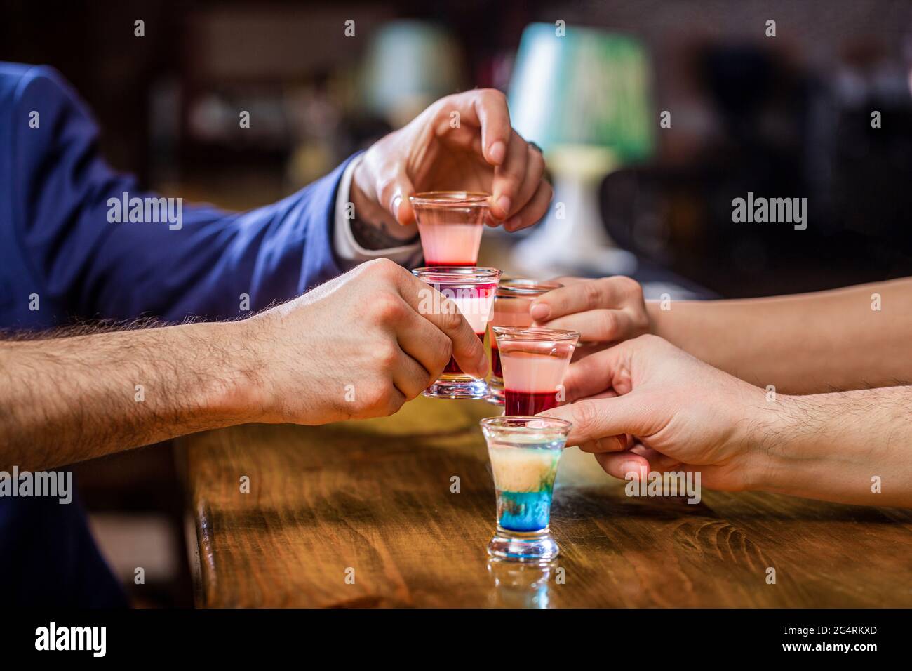 Cocktail à la discothèque. Groupe d'amis tequila shot verres au bar. Mains  mâles verres de grenaille ou de liqueur. Les amis boivent une dose ou une  liqueur. Cinq Photo Stock - Alamy