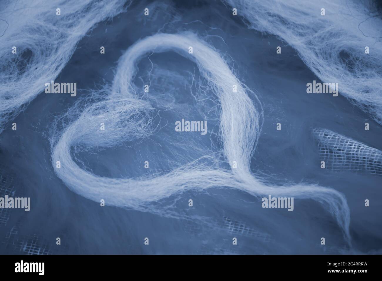 La laine bleue en forme de coeur est posée sur une laine bleue Banque D'Images