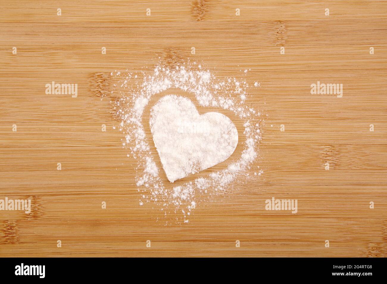 Coeur fait de farine sur fond de bambou en bois Banque D'Images